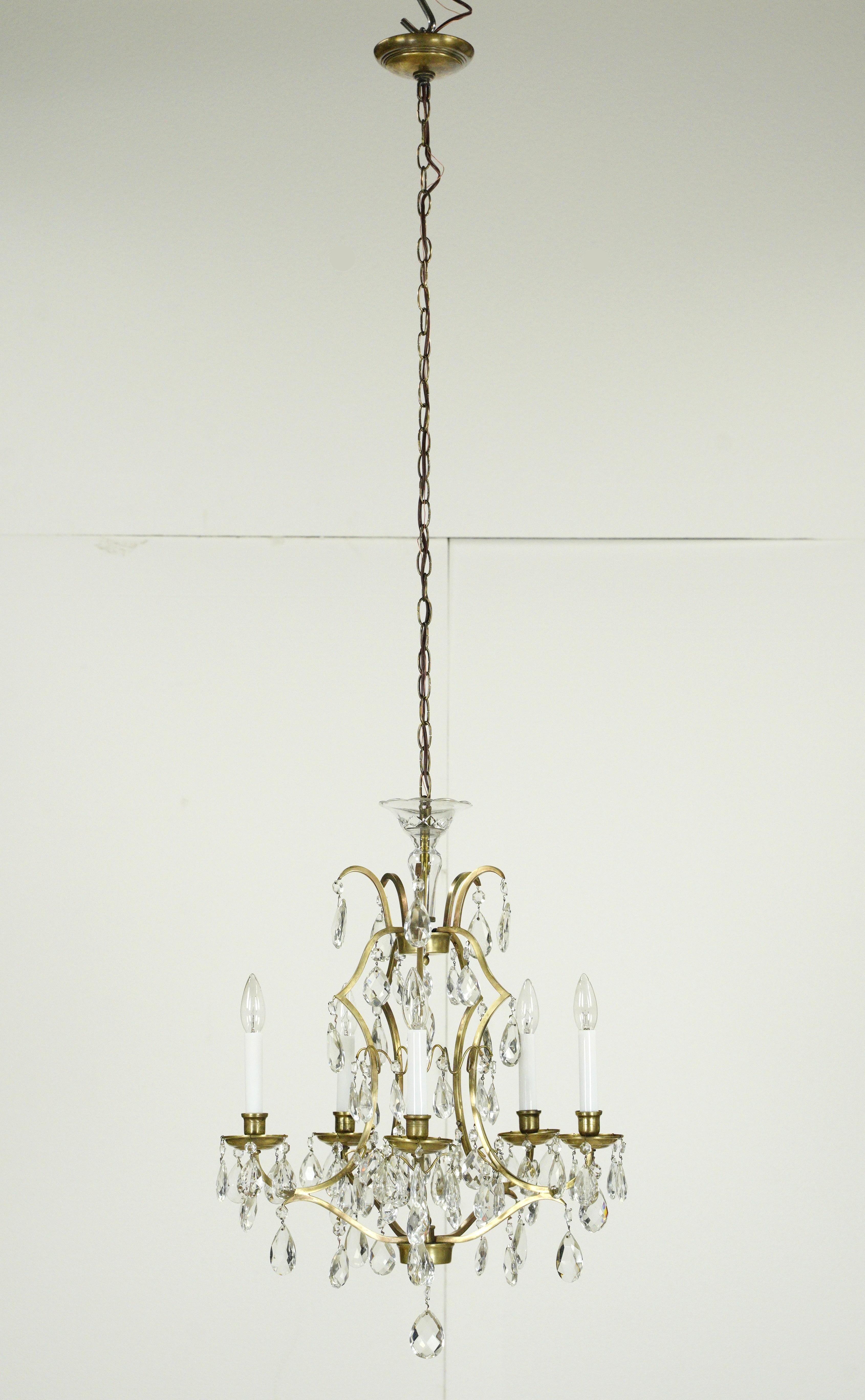 Elegant clear crystal and brass chandelier with five arms. This was acquired from the Waldorf Astoria Hotel on Park Avenue in New York City. A Waldorf Astoria authenticity card is included with your purchase. Uses five candelabra light bulbs. This