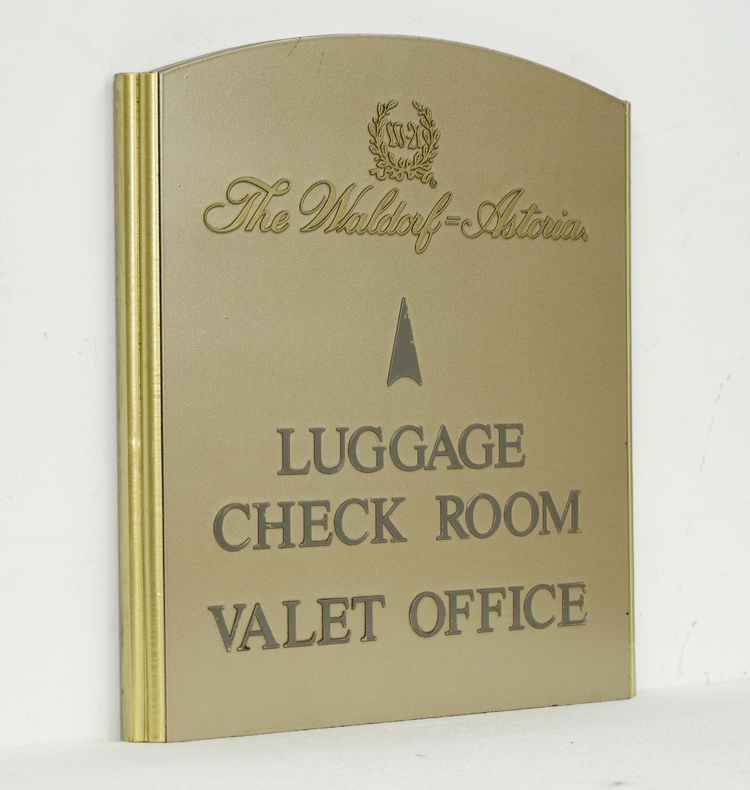 20th Century sign was sourced from the iconic Waldorf Astoria in New York City. Crafted with a painted plexiglass surface and a brass border, it signifies the Luggage Check Room and Valet Office. Elevate your décor with a genuine piece of history