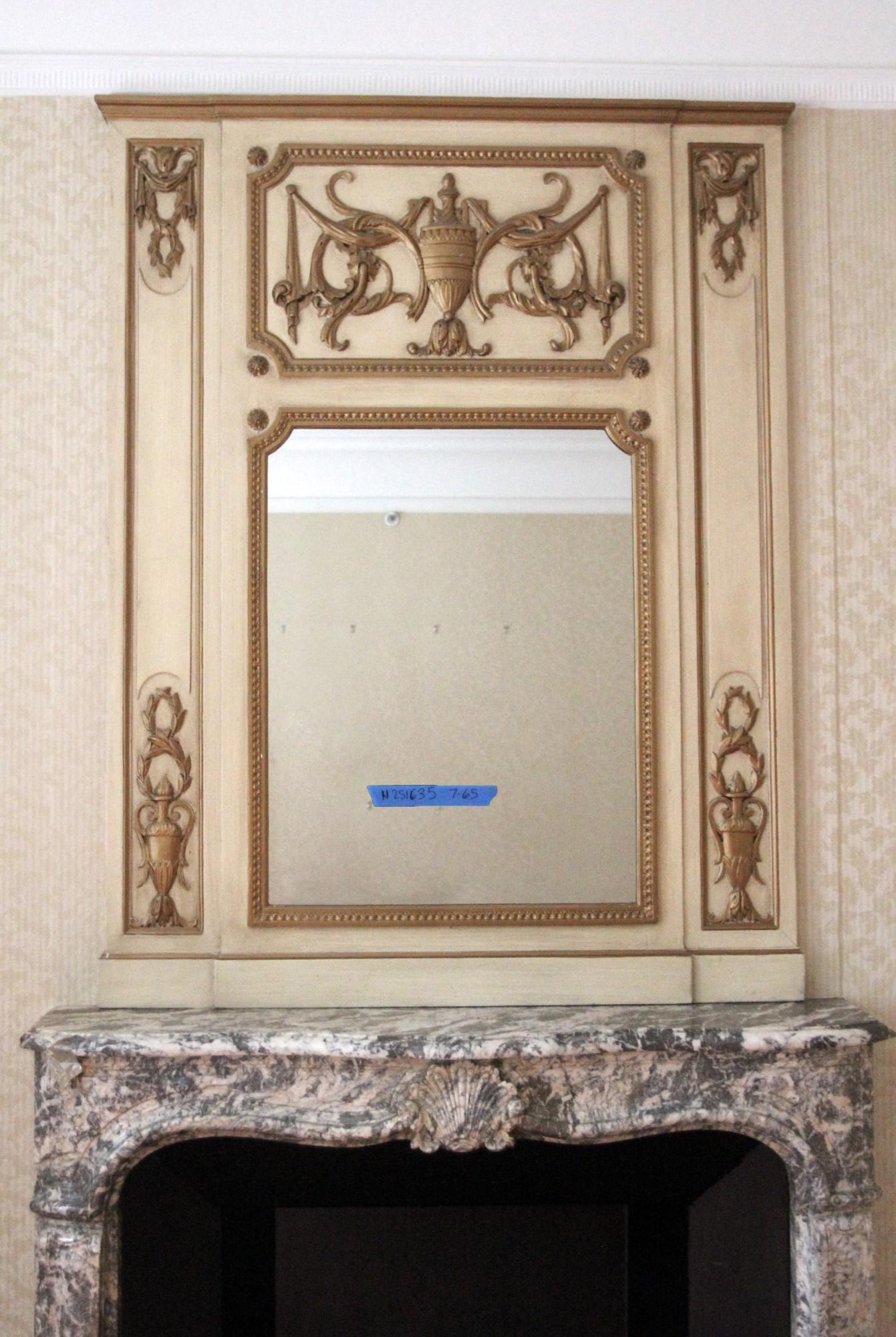 From the NYC Waldorf Astoria Hotel, this tan wood over mantel mirror has carved gold brown and gesso details including a large urn in the top center. Brought over from France this over mantel was installed in Suite 765 and dates from the 1931