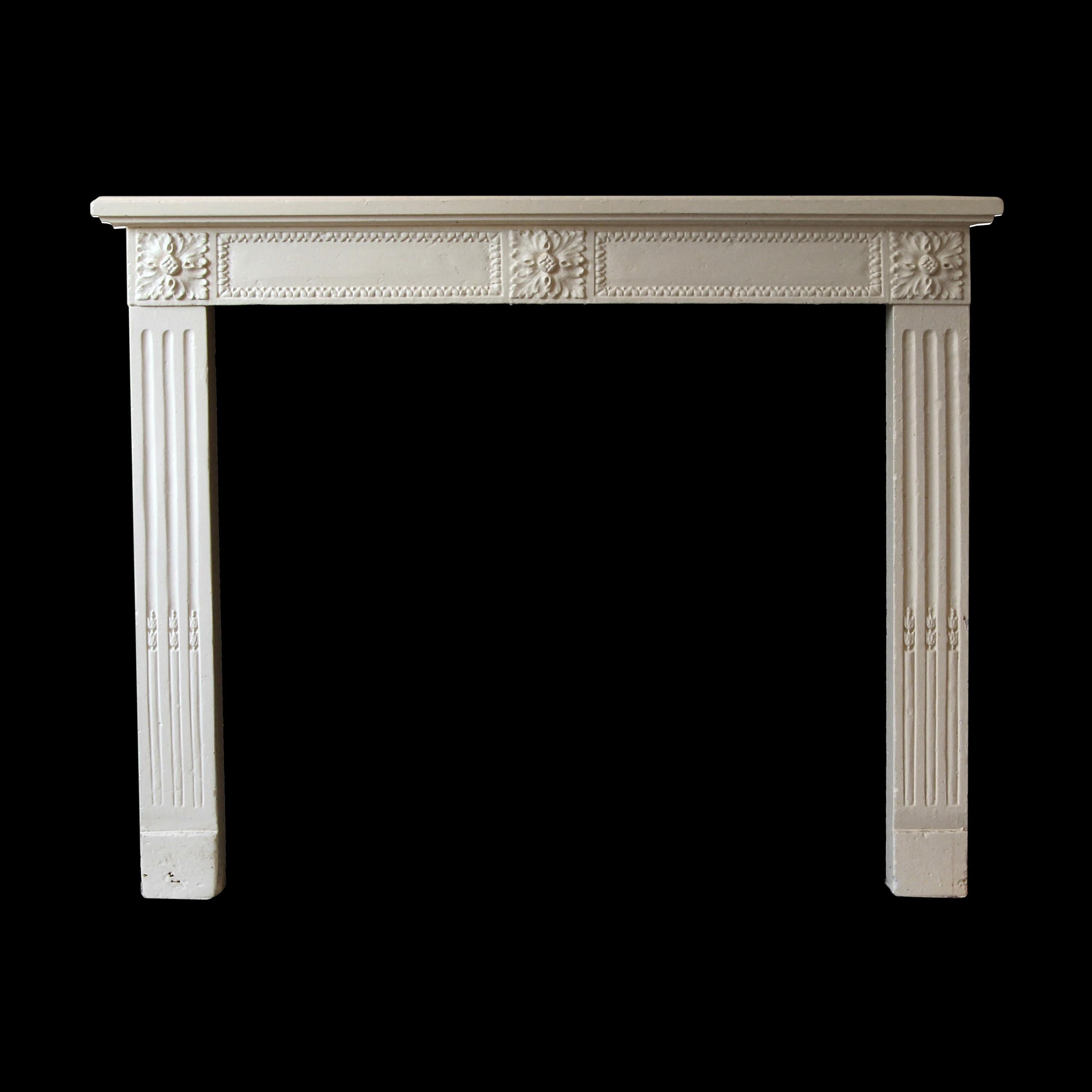 The pictured hearth is not included. Louis XVI French Regency style carved limestone mantel that has been painted a pale yellow color. This mantel has a modest design with three carved floral motifs across the apron and carved flutings on the