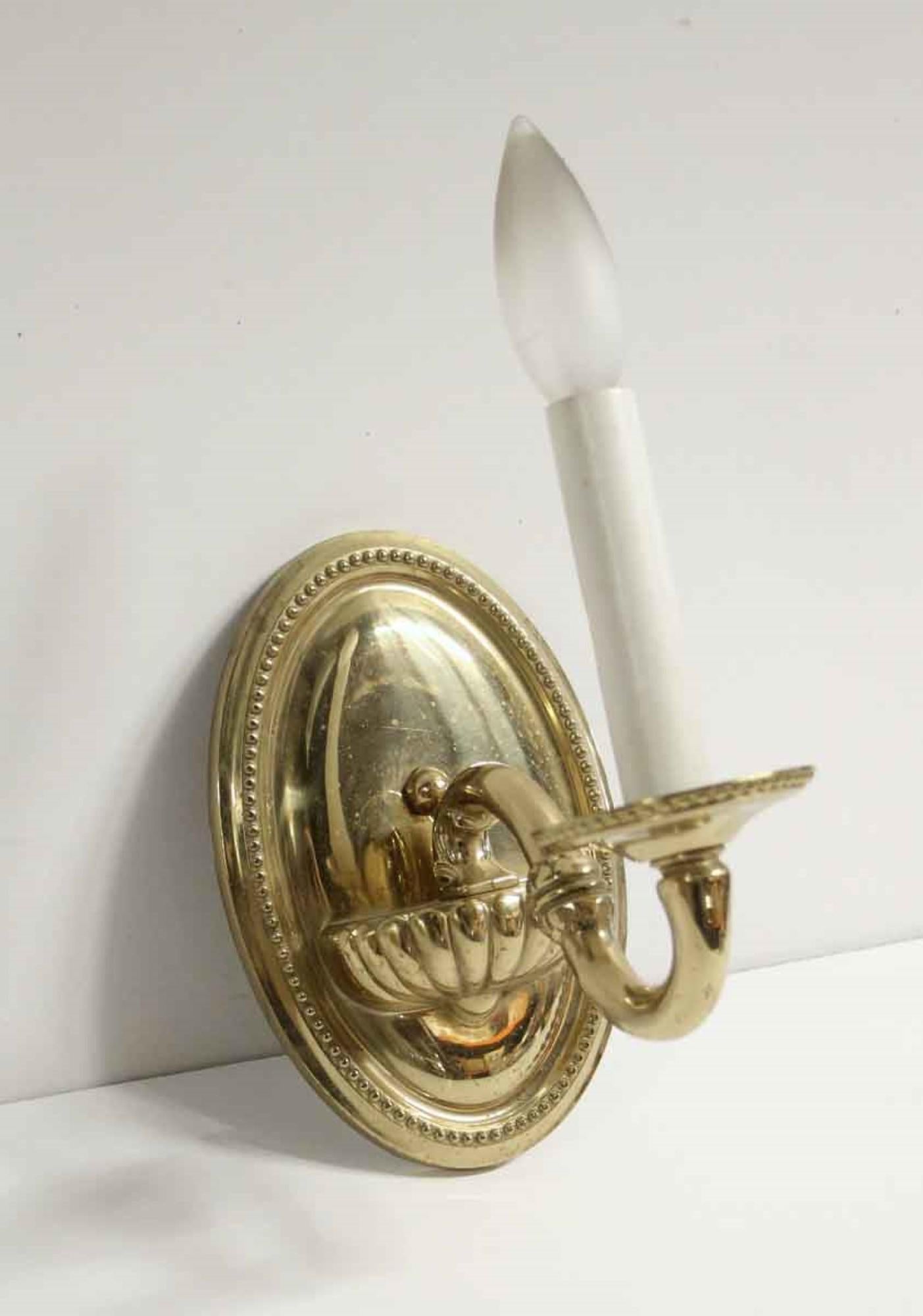 1990s polished brass beaded back plate one-arm sconce featuring a decorative base. Price includes restoration. Waldorf Astoria authenticity card included with your purchase. Small quantity available at time of posting. Priced each. This can be seen