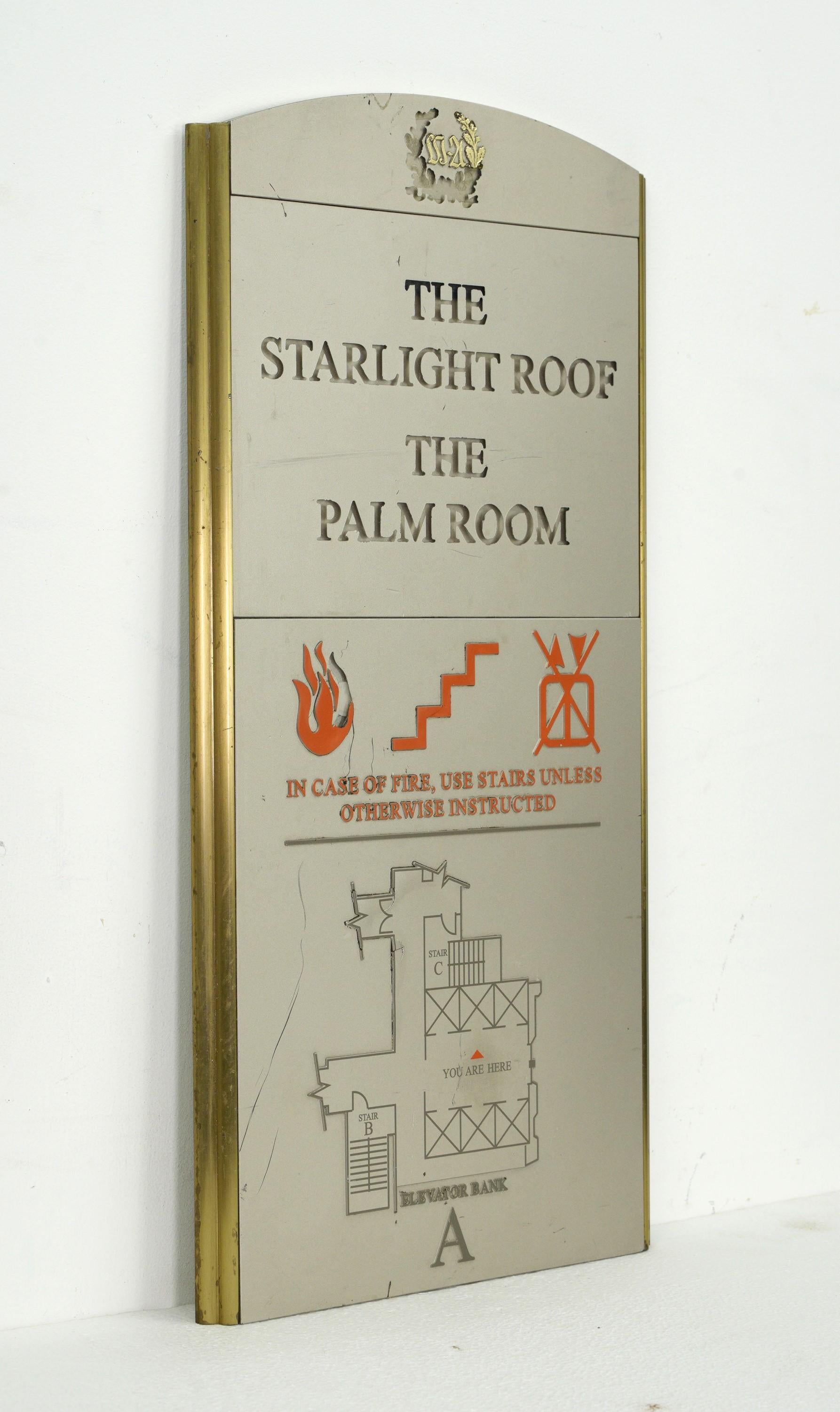 Cette enseigne de la fin du XXe siècle provient de l'emblématique Waldorf Astoria de New York. Fabriquée en plexiglas peint et avec un cadre en laiton, elle comporte des informations essentielles sur la sécurité incendie pour le Starlight Roof Palm