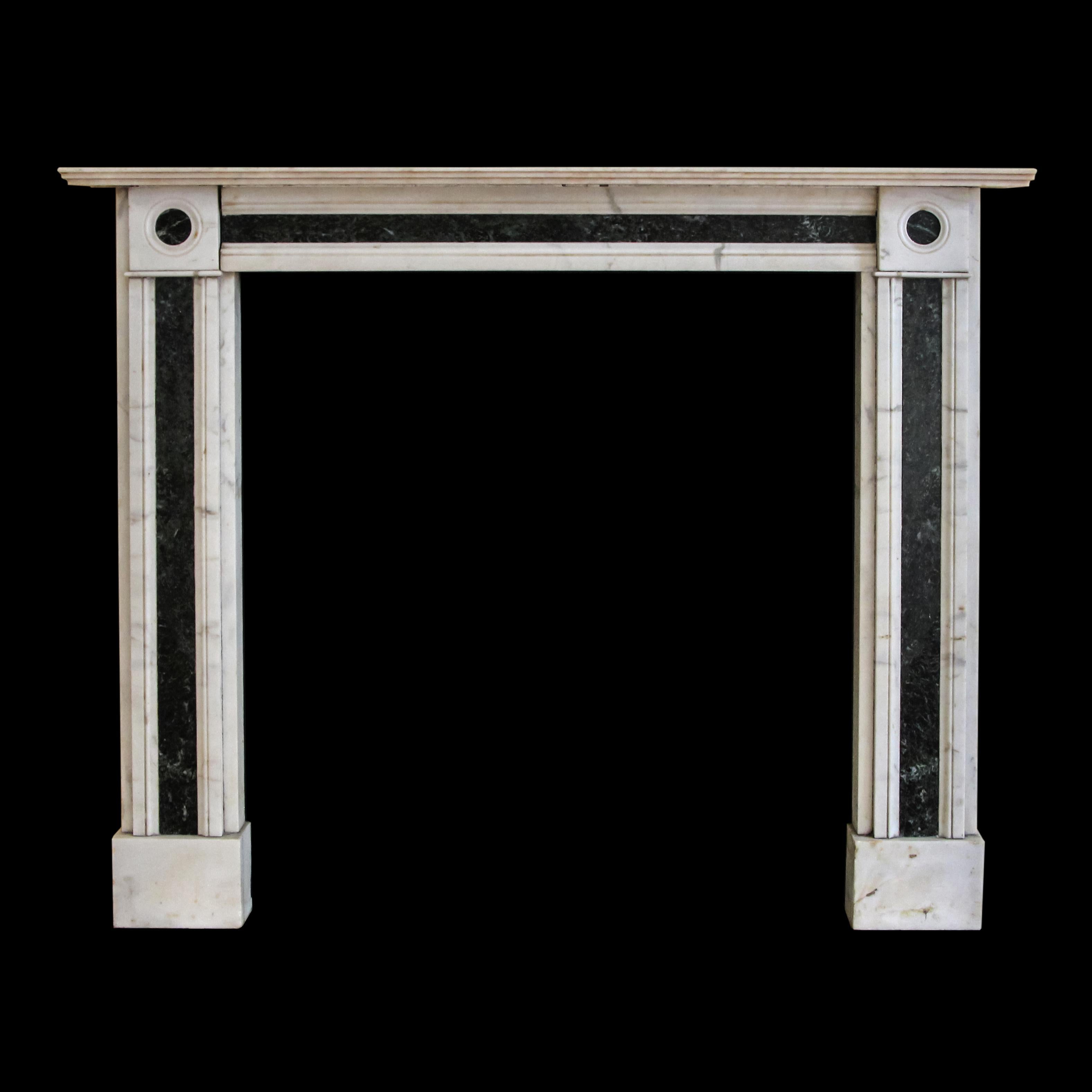 Cette petite cheminée de style Regency anglais est sculptée dans un marbre blanc chaud avec des veines grises, et incrustée de Verde Antico - un marbre vert riche avec des veines vert clair saisissantes. L'incrustation Verde Antico s'étend sur toute