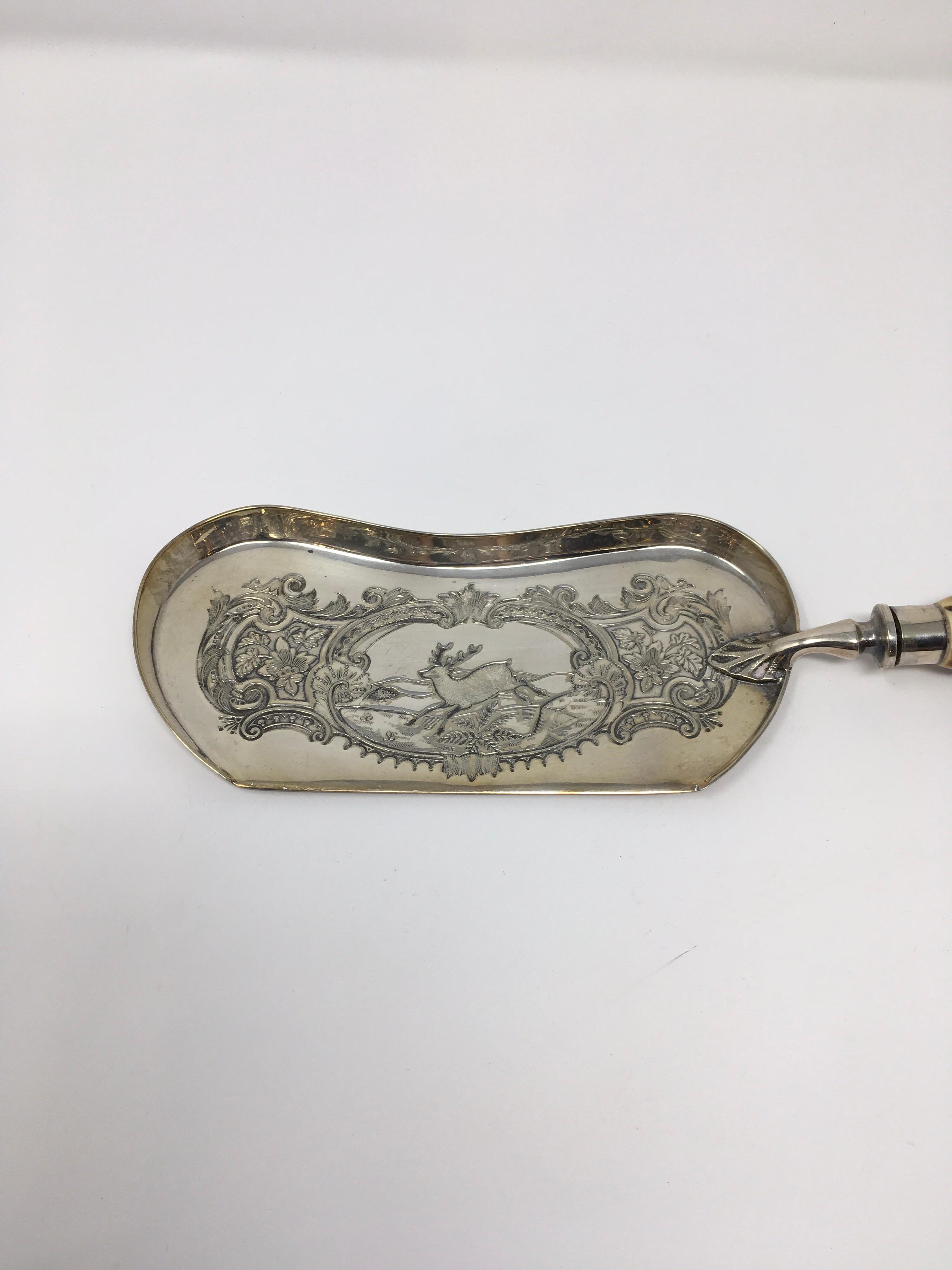This Walker & Hall bread crumber features a carved resin silver tipped handle. The silver plate blade is embossed with a deer and lovely scroll work. The hallmarks on the bottom of the blade lead us to believe the piece was made between 1930-1950.