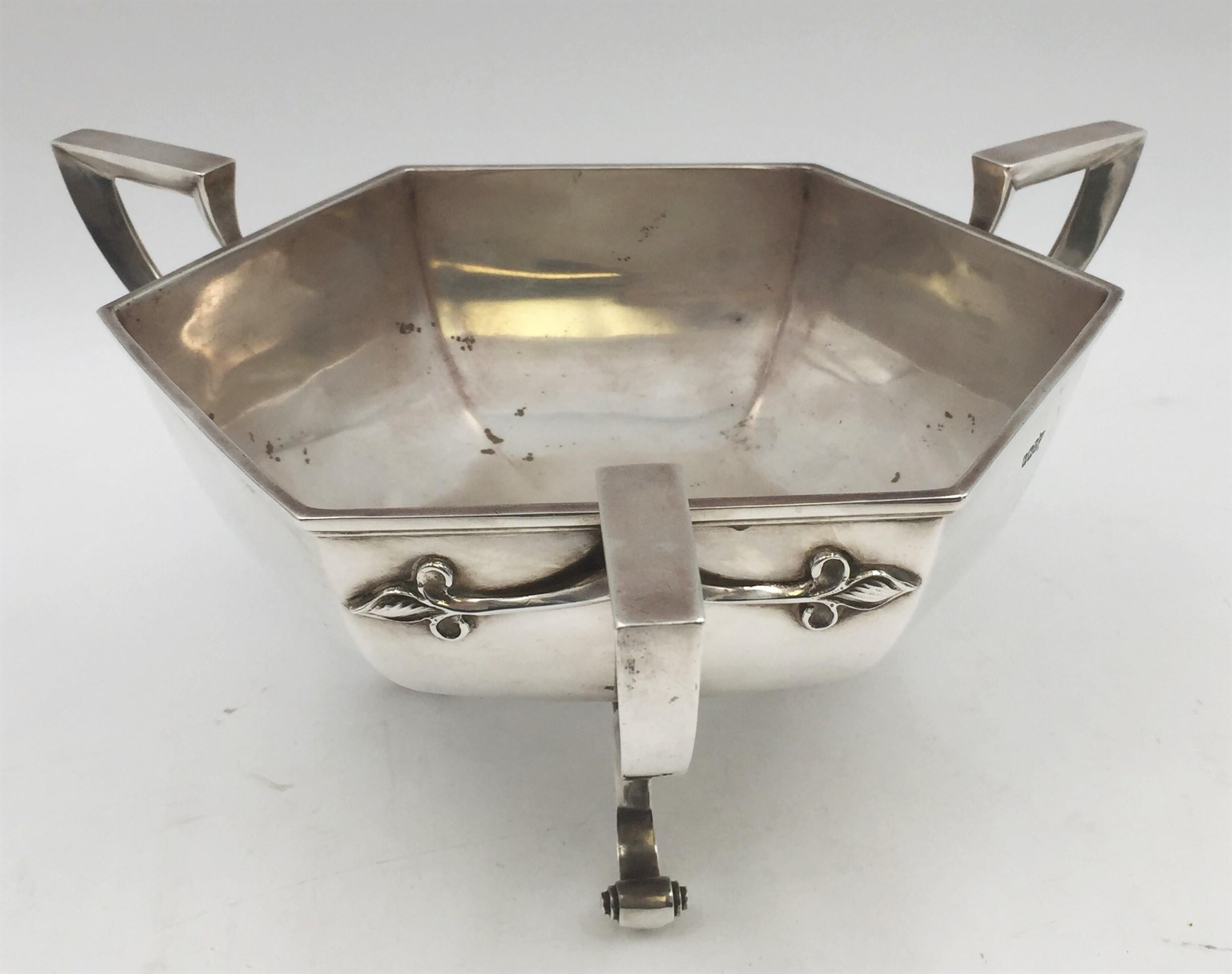 Walker & Hall sterling silver centerpiece bowl from 1904, made in Sheffield, England. This hexagonal-shaped bowl stands on three curvilinear legs, has three handles with applied motifs which are characteristic of the Art Nouveau style, and a