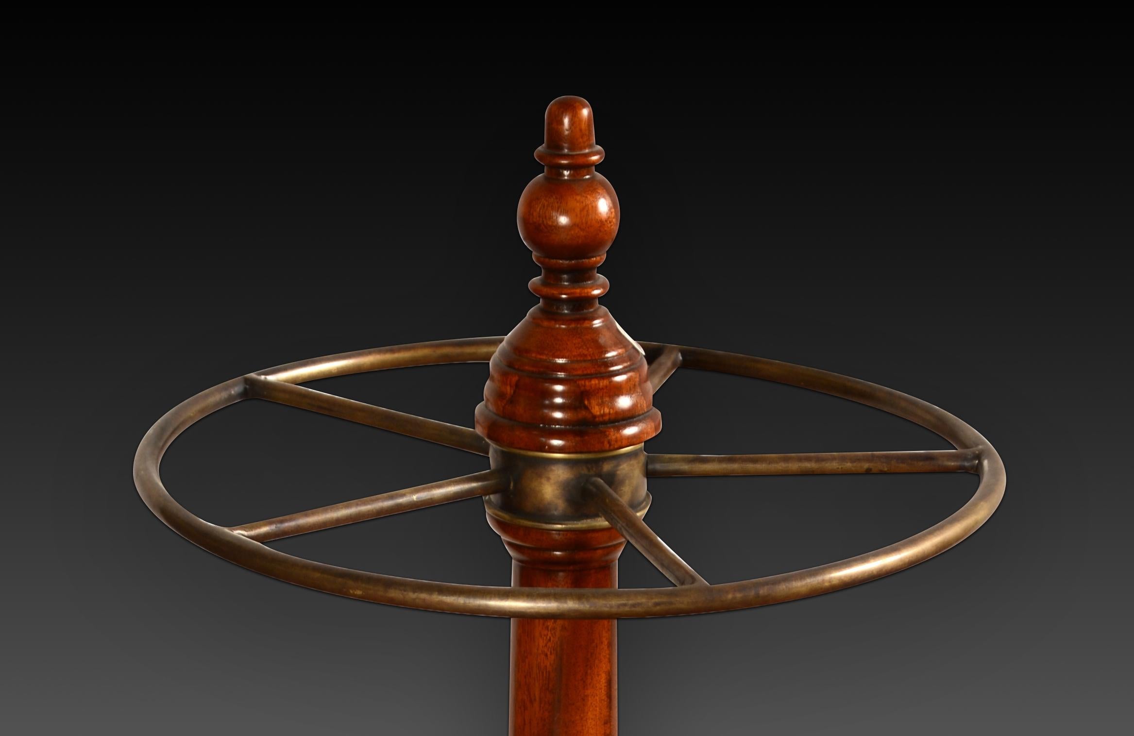Walking stick or umbrella stand. Mahogany wood, metal. 20th century.
 Furniture to hold canes and umbrellas made up of a lower circular piece with a metal interior and a wooden exterior decorated with fine moldings and a ready wooden shaft topped