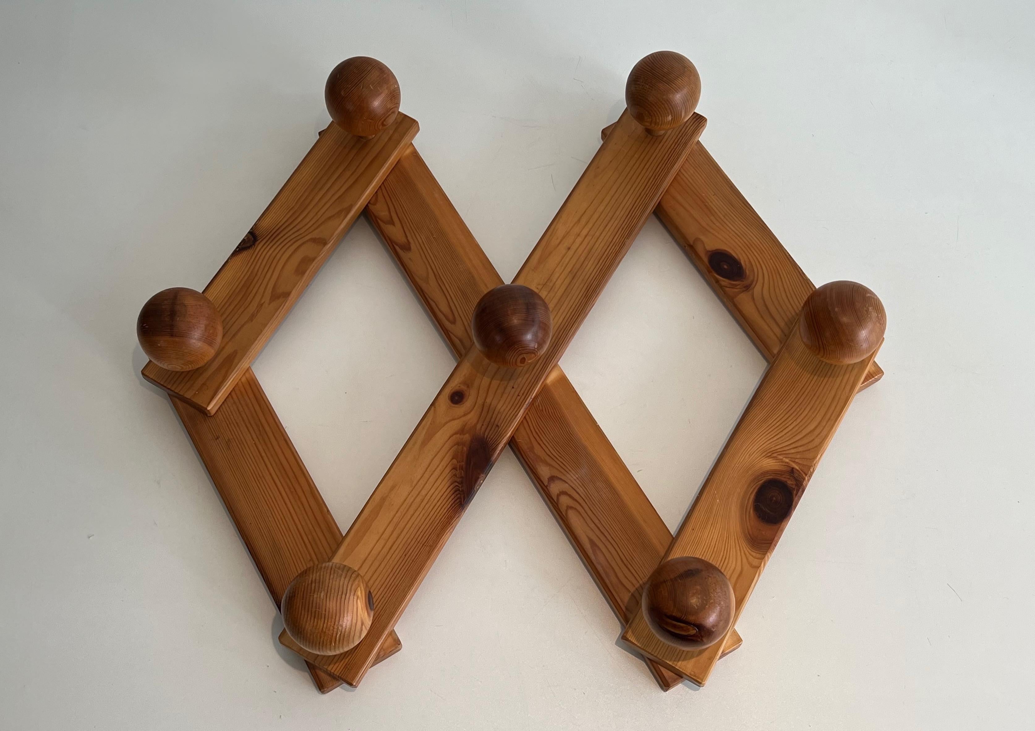 This interesting and decorative coat hanger is made of pine. This is an accordion model which allows the coat hanger to be adjustable in width or height. This is a French work in the style of very famous designer Charlotte Perriand. Circa 1970
