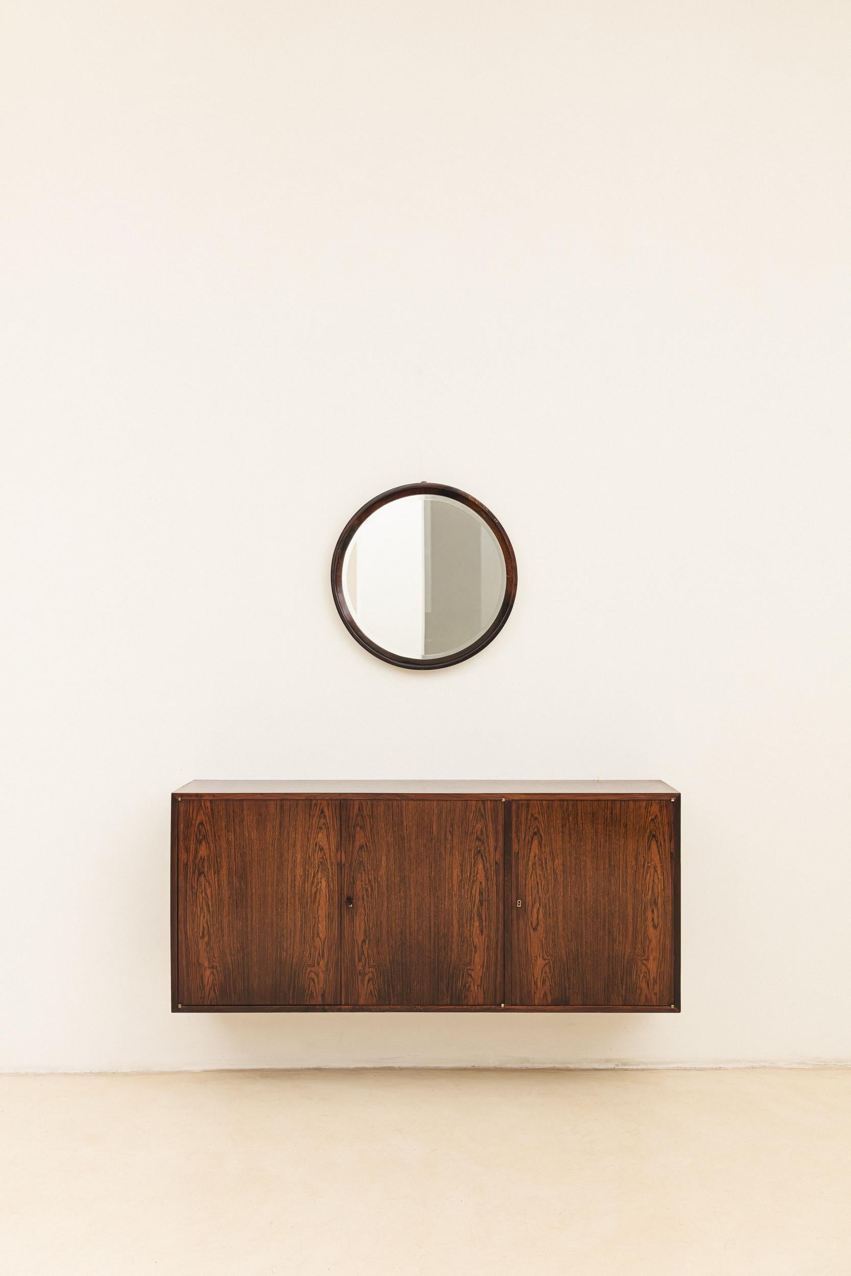 Fabricado en los años 60 por Celina Decorações, este armario de pared está hecho de madera contrachapada con chapas de palisandro, con hermosas vetas y variaciones de color. Sus herrajes han sido cuidadosamente elaborados y los detalles de las