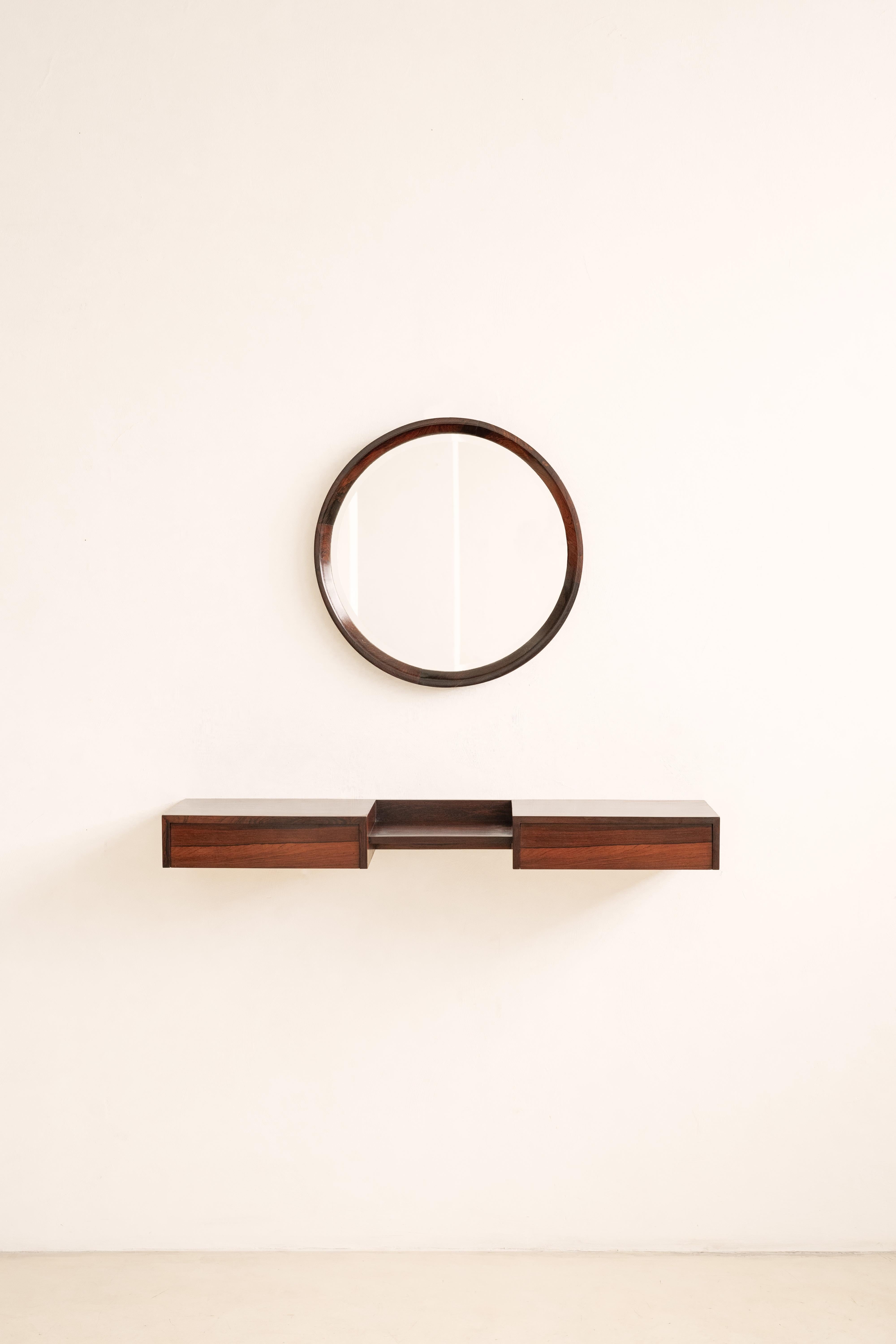 Fabricado en los años 60 por Celina Decorações, este armario de pared está hecho de madera contrachapada con chapas de palisandro, con hermosas vetas y variaciones de color. Tiene dos cajones unidos por una pequeña balda.

Fundada en 1938 en Río de