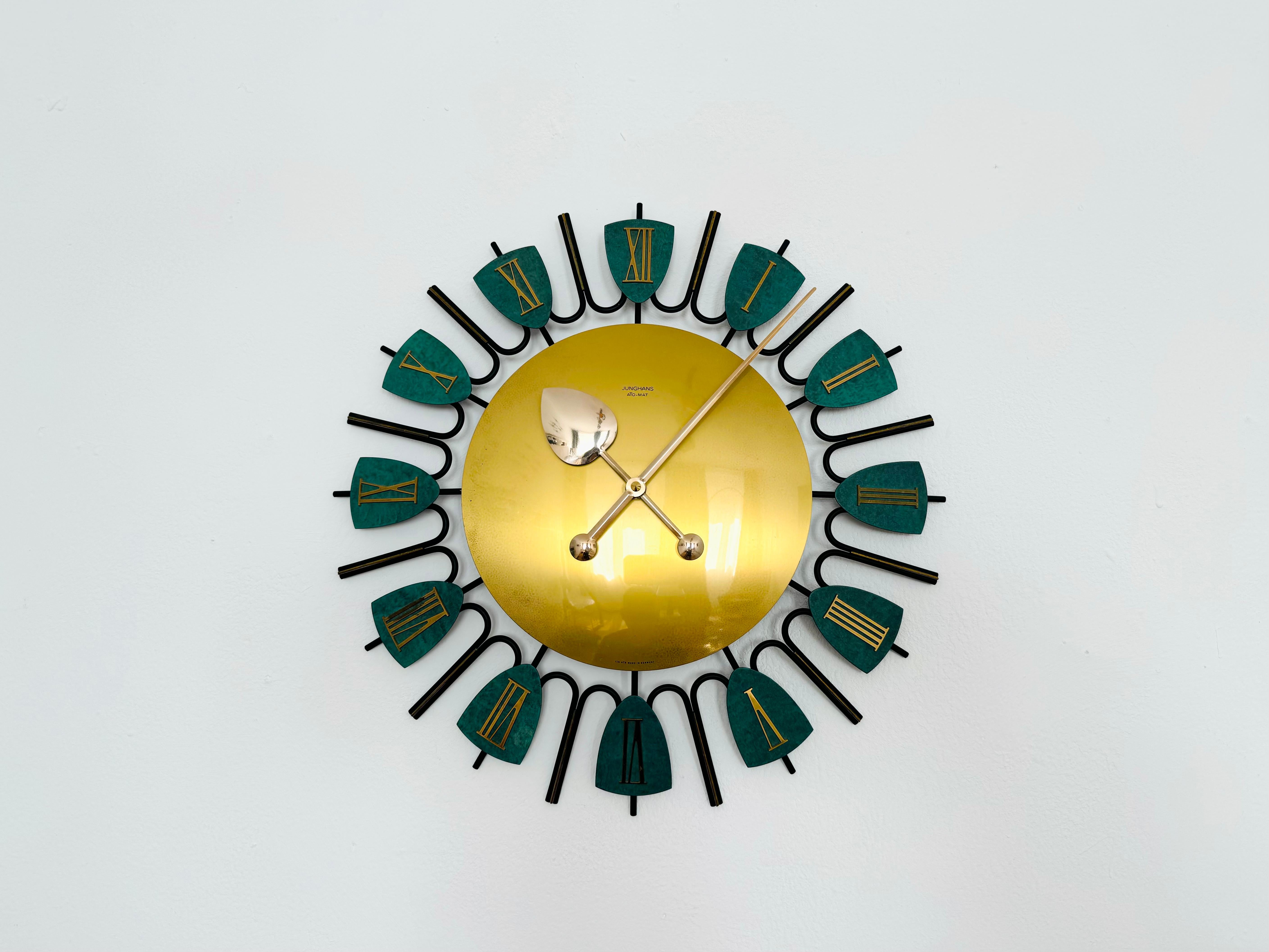 Wonderful brass wall clock from the 1950s. 
Charming design by Junghans and excellently crafted.

Manufacturer: Junghans
Around 1950

Condition:

Very good vintage condition with slight signs of age-related wear.
Patina and signs of wear in