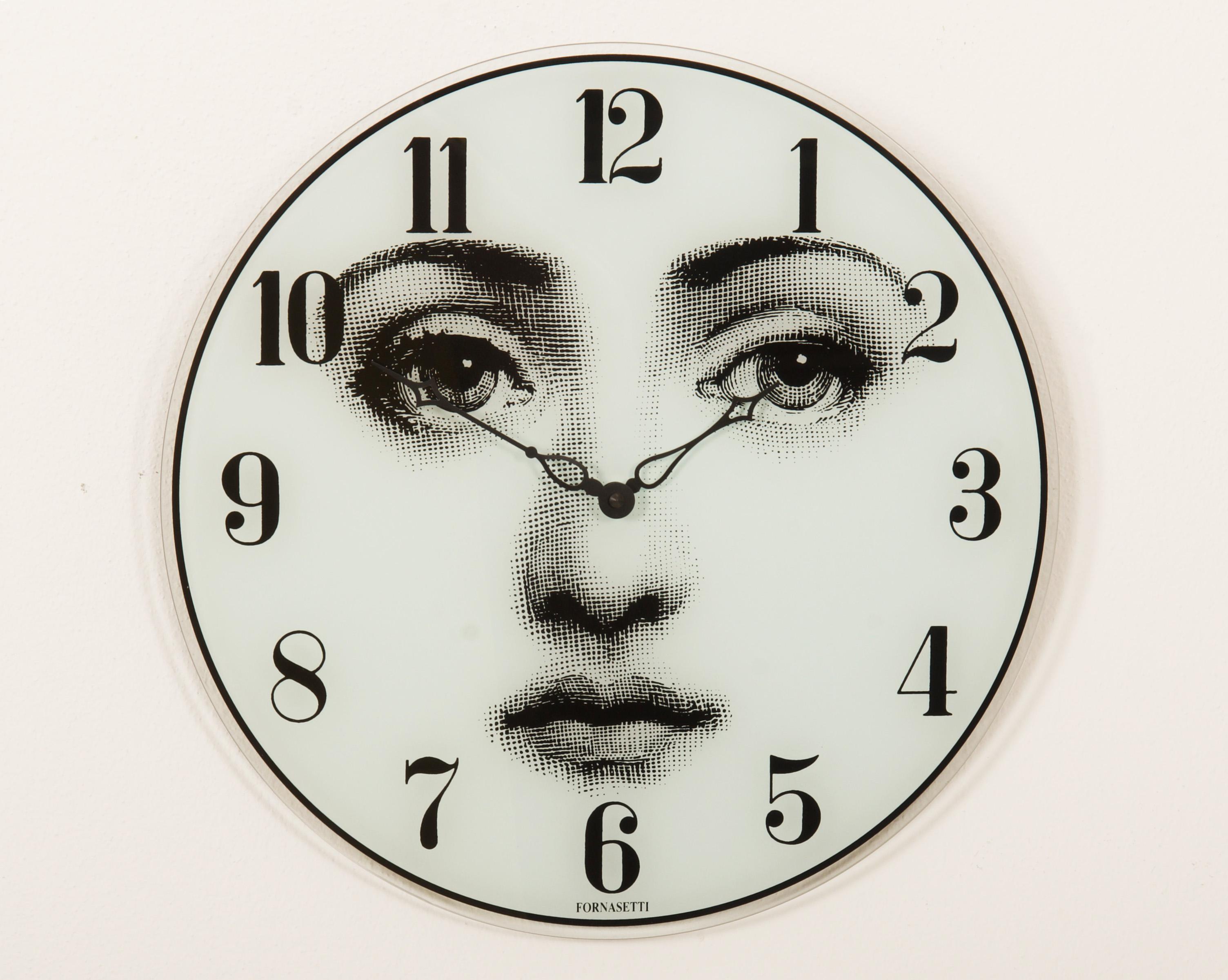 Horloge murale Piero Fornasetti créée dans les années 1990. Horloge en verre avec visage de femme et chiffres imprimés, avec mécanisme d'horloge à quartz. Mesures : Ø 37 cm.
