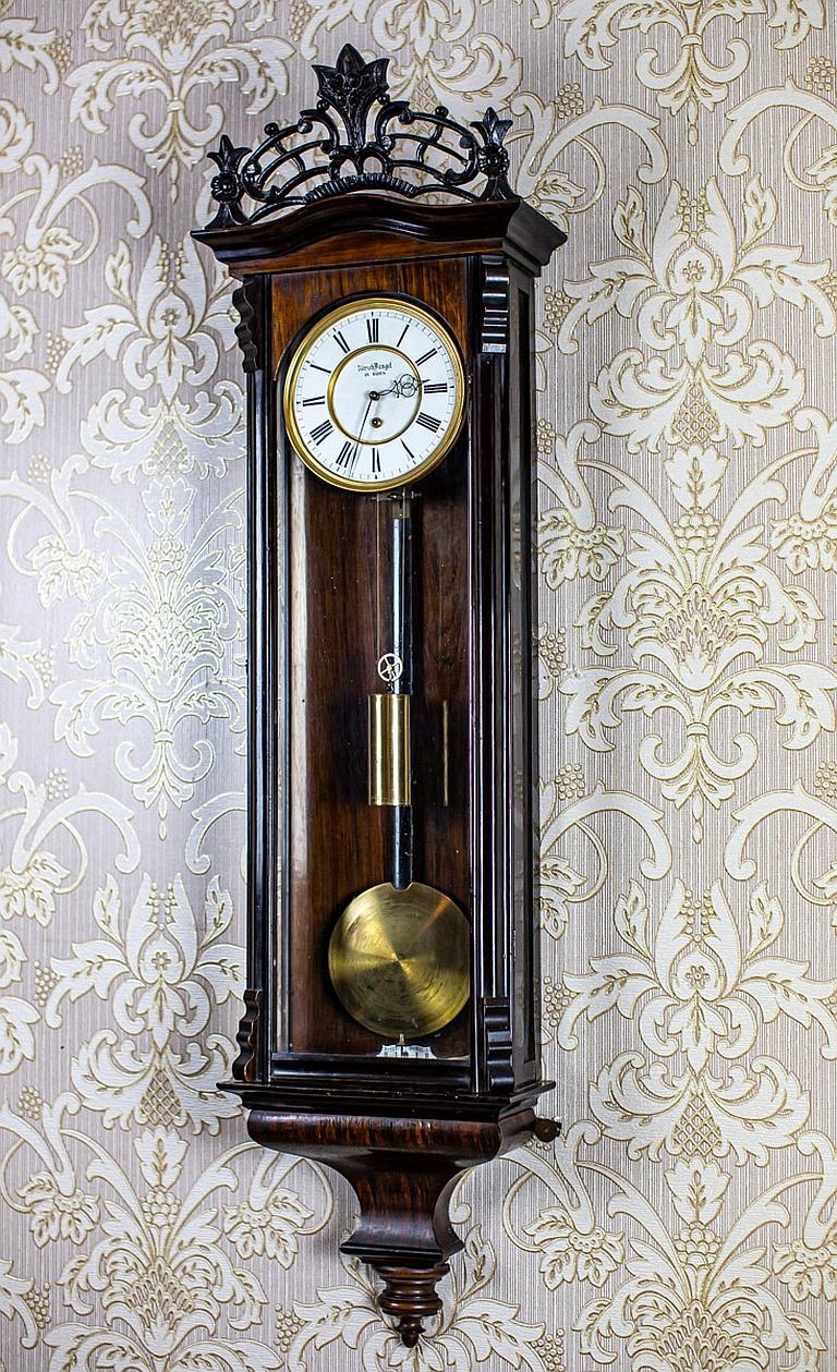 Austria-Hungarian Wall Clock From the Late 19th Century

We present you this wall clock from the late 19th century (probably 1870) manufactured in Austria-Hungary.
The gravity winding mechanism with a weight is functional and has undergone a