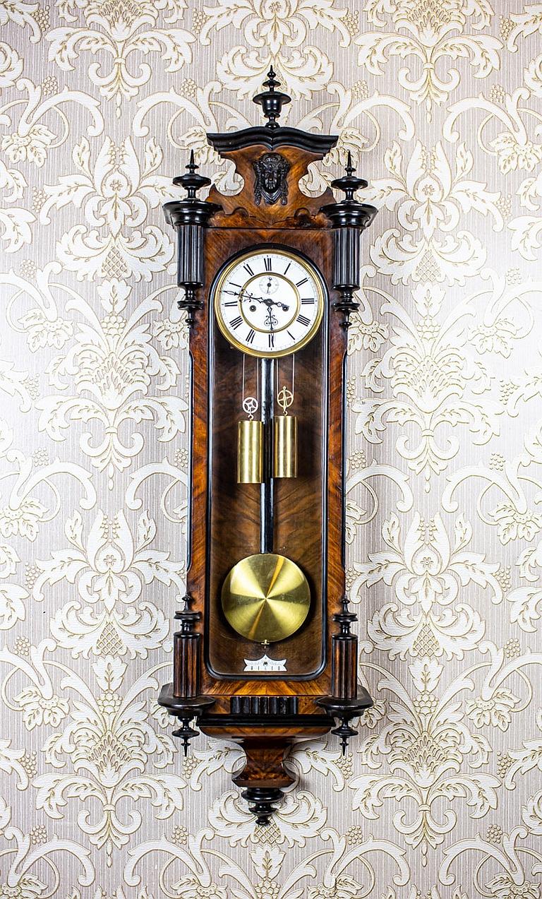 Wall Clock from the Late 19th Century in Brown Walnut Case

We present you this wall clock in an eclectic wooden case.
The face is porcelain, with Roman numerals.
Furthermore, the weights and pendulum are made of brass.
The clock strikes full hours