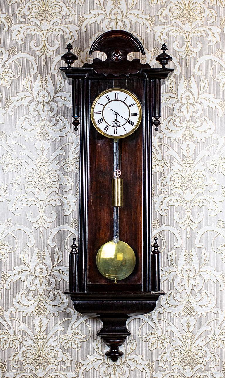 Wall Clock from the Late 19th Century in Black Glazed Wooden Case

We present you this wall clock in a glazed wooden case.
The case is painted black and has not undergone renovation.
The face is enameled. Both the pendulum and weights are made of