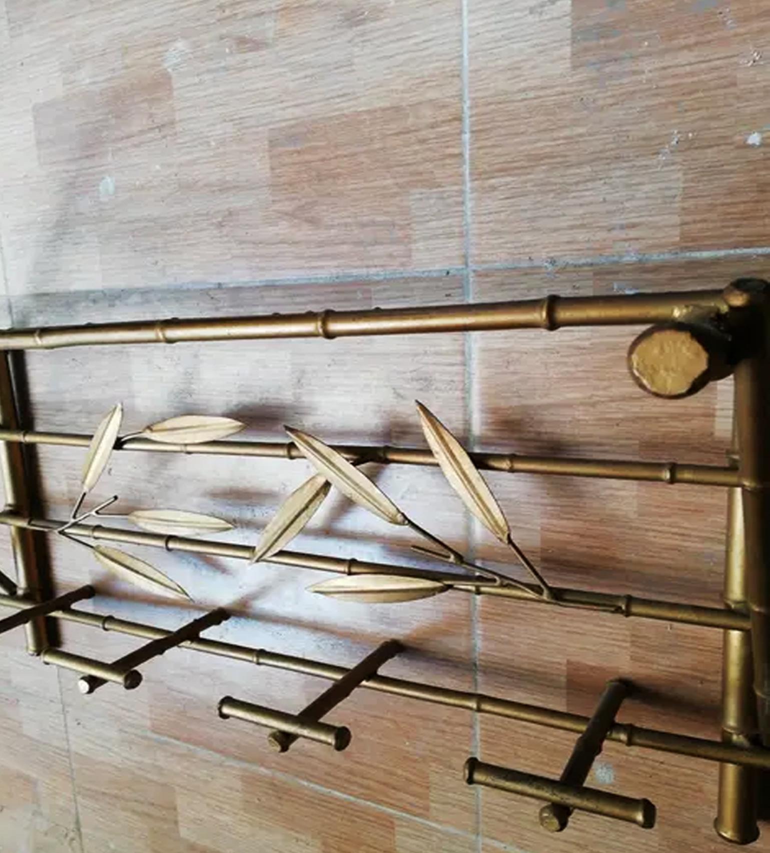 Wall coat rack faux bamboo Holliwood Regency Style. Golden iron with decorated leaves
 It has 4 hangers and an upper space to put hats or bags when you enter your home.
t is an Iron wall coat rack with gold leaf, with a design of Leaves embedded in