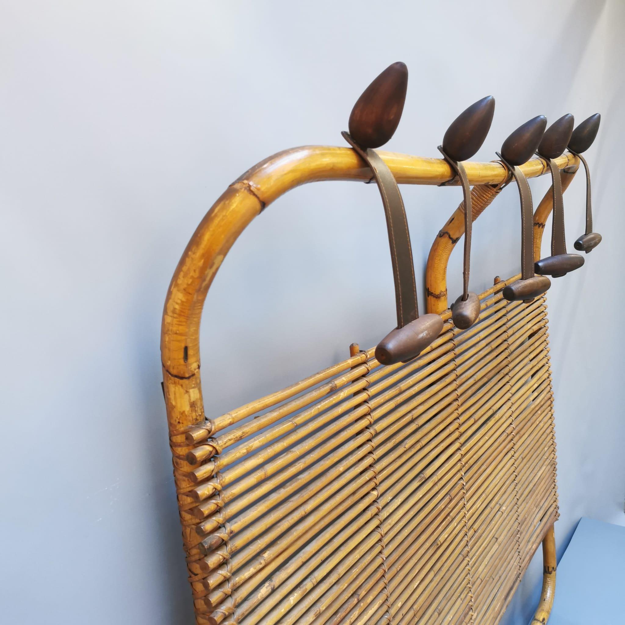 A rattan wall hanger with a modern design. An incredible piece of the 60s, a period of splendor of Italian design, to remember in fact the projects of Tito Agnoli for Bonacina. This hanger is in really good condition, it didn't need any restoration.
