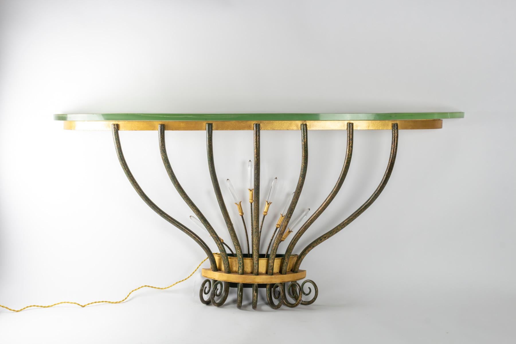 Wall console, golden and patinated wrought iron, crystal pendants, lighting at the base on the bouquet of pendants, slab of
Saint-Gobain glass, 1950 period
Measures: L 140cm, P 26cm, H 64cm.
