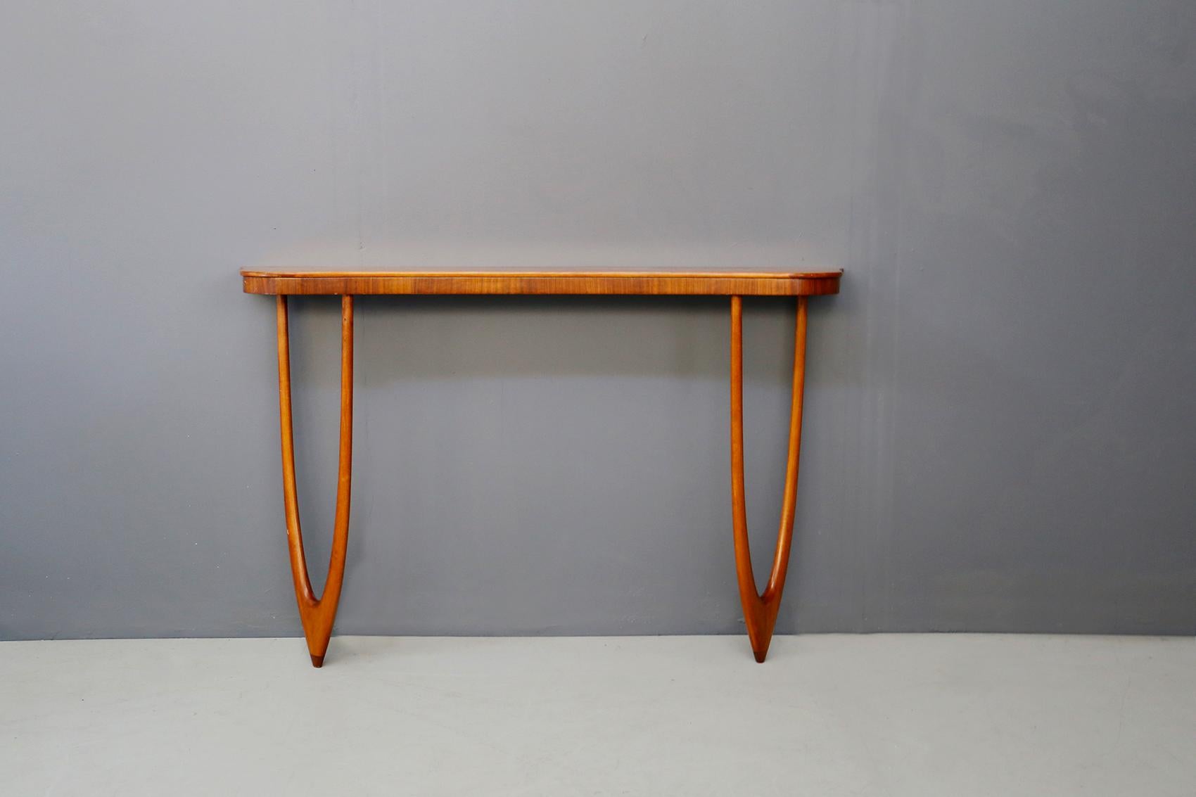 Elegant wall console attributed to the Italian designer Cesare Lacca of the 1960s. The console is made of oakwood and is designed with two curved wooden legs. The peculiarity of the console is its semi-oval shaped legs that support its support