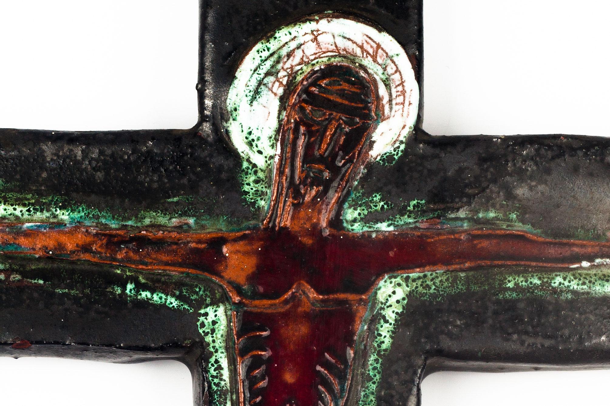 Large crucifix in matte textured and glazed ceramic, handmade made in Belgium in the 1970s. Matte cross in dark and light green, brown, red, white with glazed red-brown Christ figure at its centre. 

This piece is part of a large ceramic crucifix