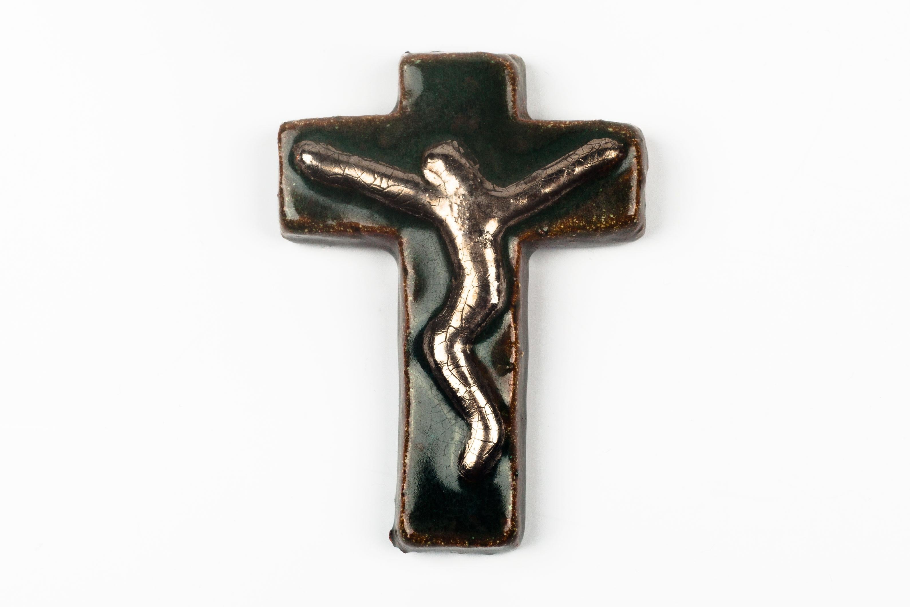Preciously small crucifix in glazed ceramic, handmade made in Belgium in the 1970s. Glossy deep green and brown with metallic gold raised christ figure at its center.

This piece is part of a large ceramic crucifix collection, all made in Belgium