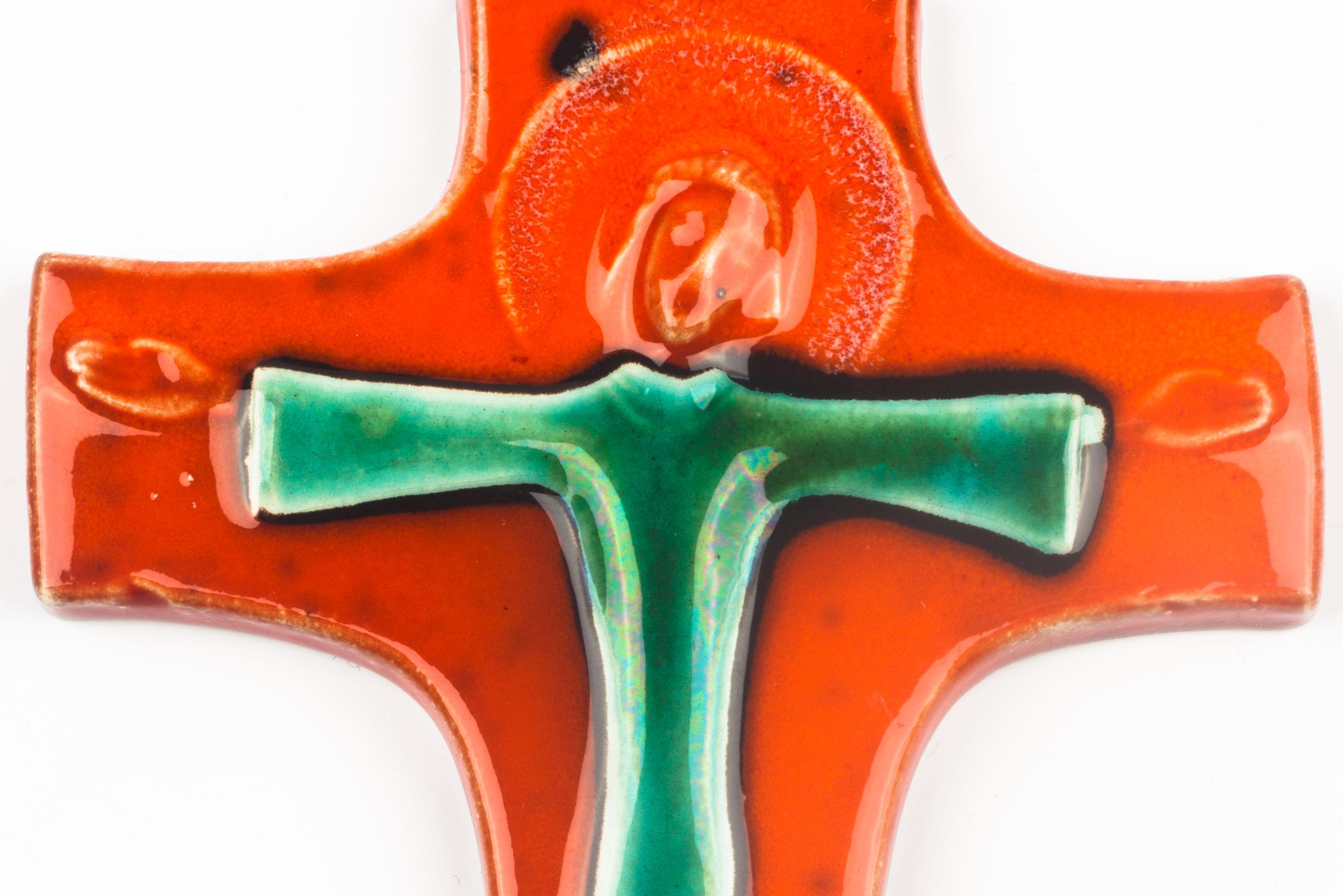 Crucifix in glazed ceramic, handmade made in Belgium in the 1970s. Glossy bright orange, green and black & white cross with raised christ figure at its center.

This piece is part of a large ceramic crucifix collection, all made in Belgium between