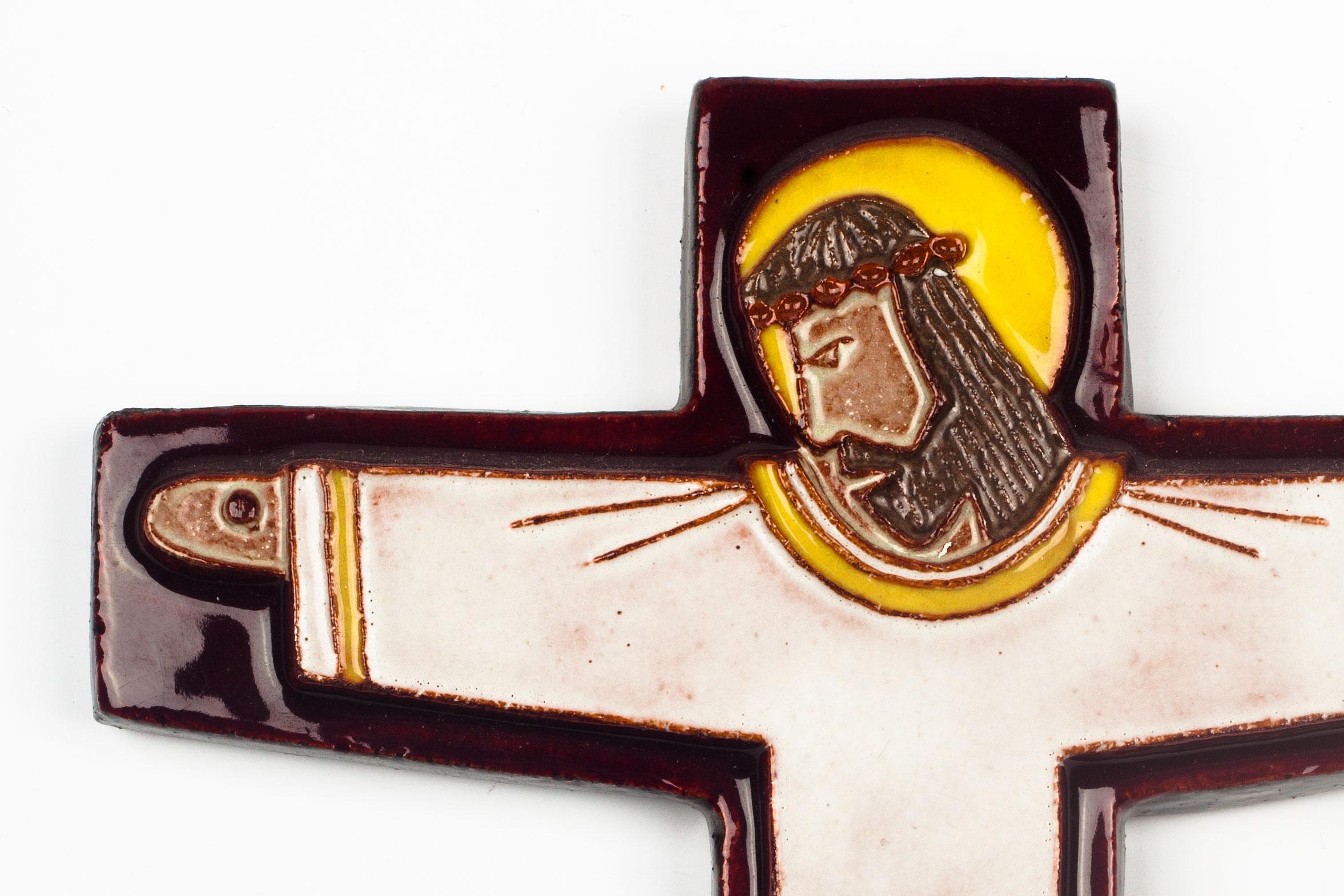 Crucifix in glazed ceramic, handmade made in Belgium in the 1970s. Red-brown, burgundy cross with yellow, white, brown raised christ figure at its center.

This piece is part of a large ceramic crucifix collection, all made in Belgium between the