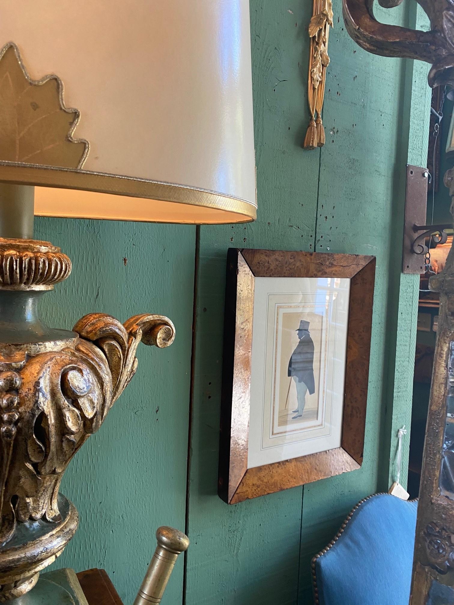 This Silhouette portrays the 19th century gentleman With his pointy cane. This item has been well taken care of and has minor wear consistent with its age. Wall art silhouette of an older Gentleman framed in a Thuya Burl or possible bird's-eye