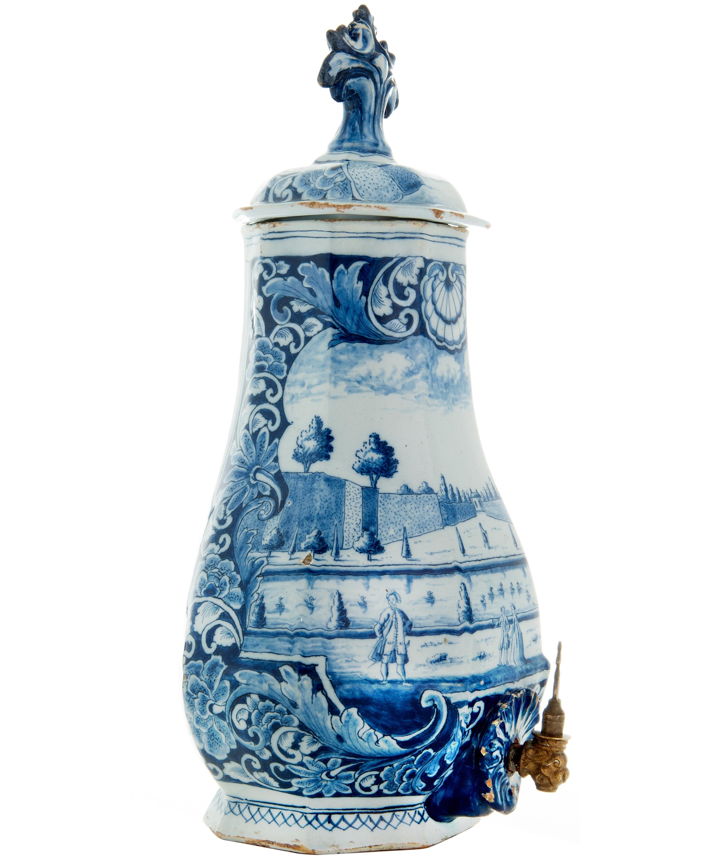 This fountain is a splendid example of a luxury utensil decorated entirely in blue - white faience. The object is richly decorated with personages in a garden. The fountain could be filled with water, it probably hung in a corridor or was part of a