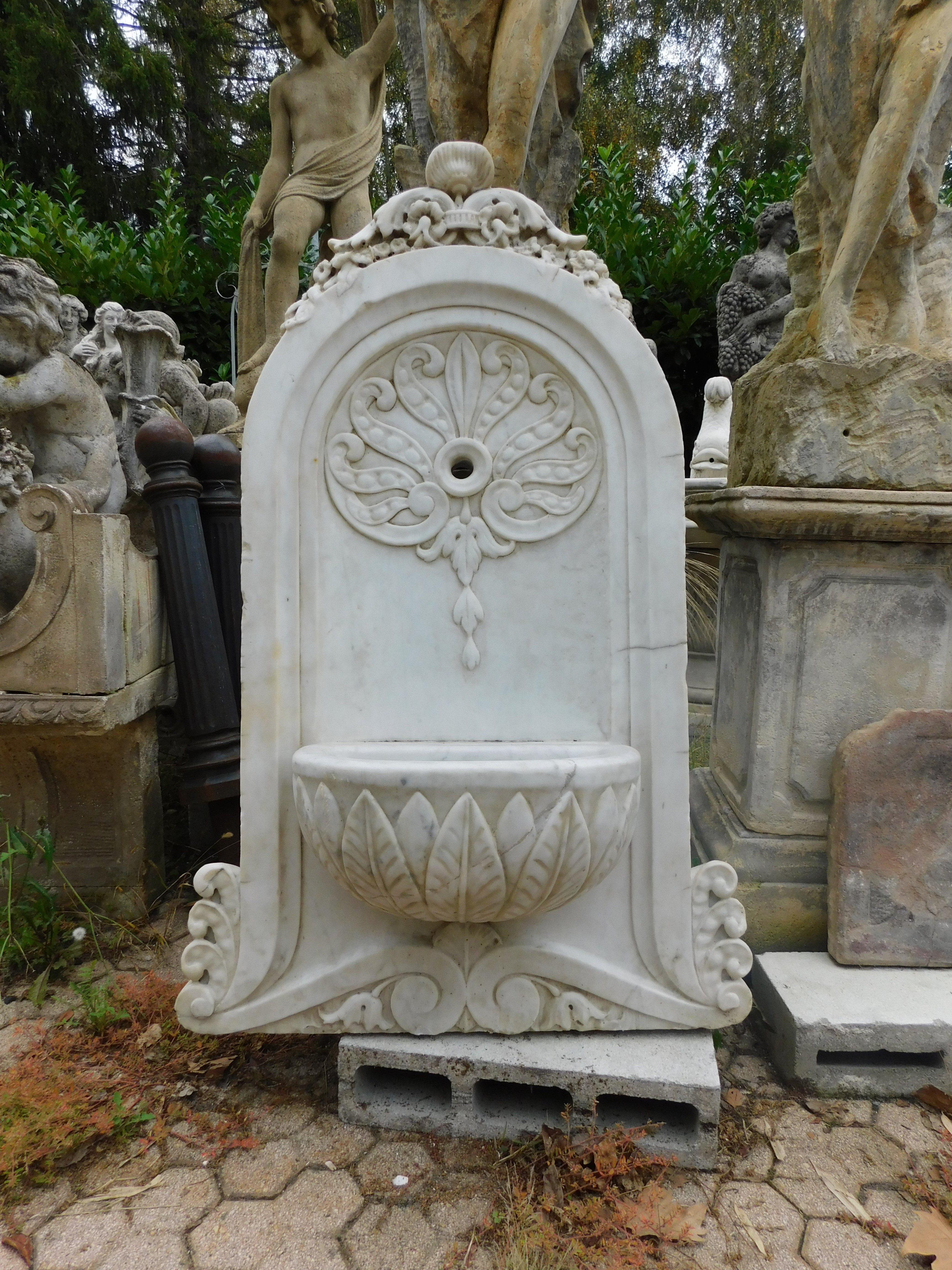 Ancient old wall fountain, fountain in white Carrara marble, richly carved with leafy decorations and hole for water nozzle, built in Italy in the 19th century, Maximum dimensions cm W 78 x H 123 x D 39