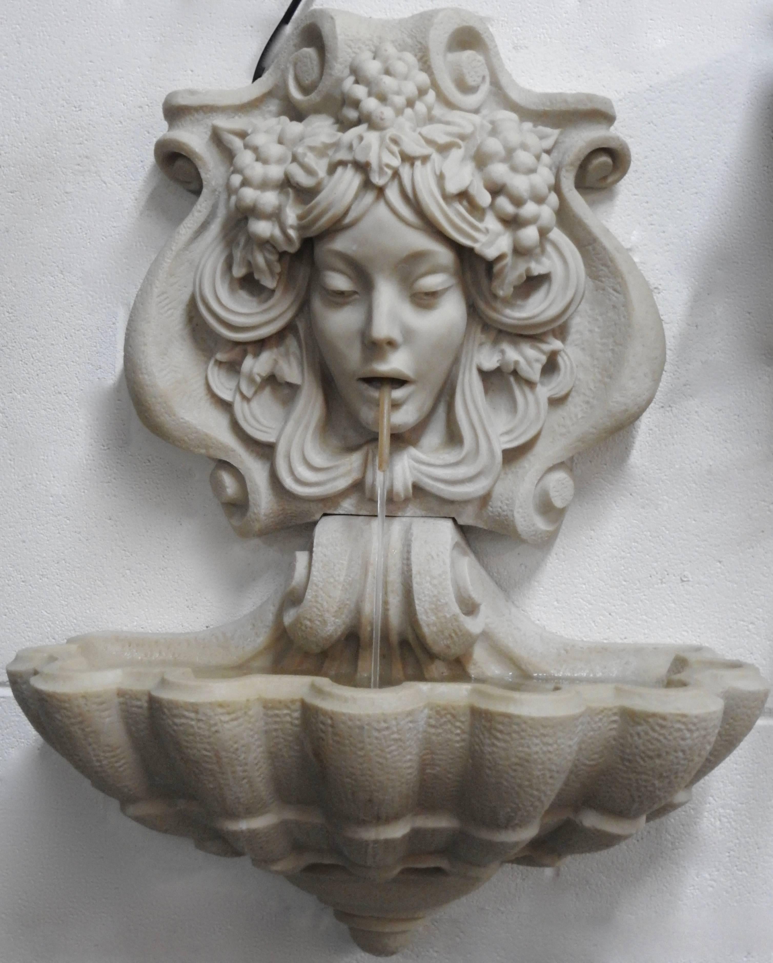 This lovely lady that forms a wall fountain would be happy to adorn your surroundings. She is surrounded by grapes and waves of hair. The water flows from a tube in her mouth to the shell style basin. The pump is included and is in working condition.