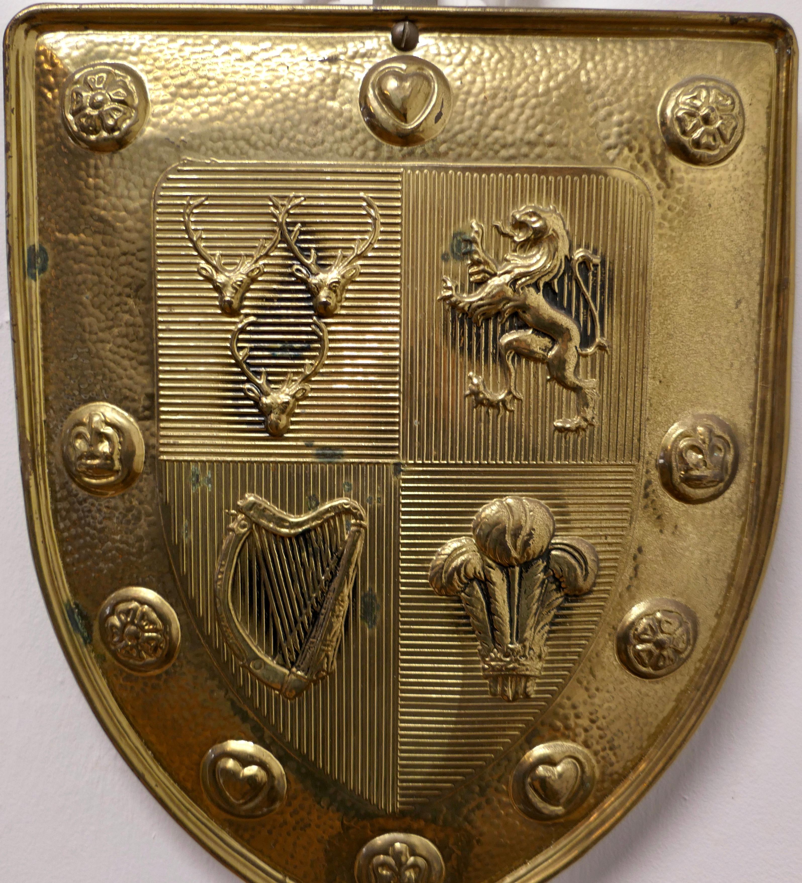  Wall Hanging Arts and Crafts Brass Shield with Sword 

This is a Decorative wall piece the shield is beaten and has a Lion Rampant, Prince of Wales Feathers, Stags and a Harp denoting all the country’s of the British Isles  
The sword is fixed held