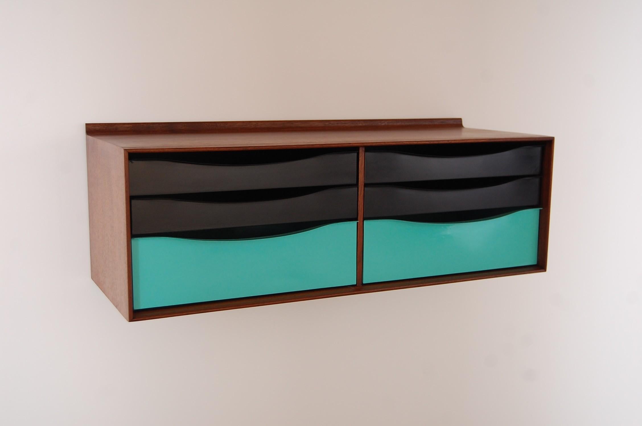 Hanging cabinet in walnut and metal, circa 1964. Walnut cabinet has been professionally refinished, and the six metal drawers have been re-lacquered with colors closely matching the colors they were in when we acquired the cabinet. We can change the