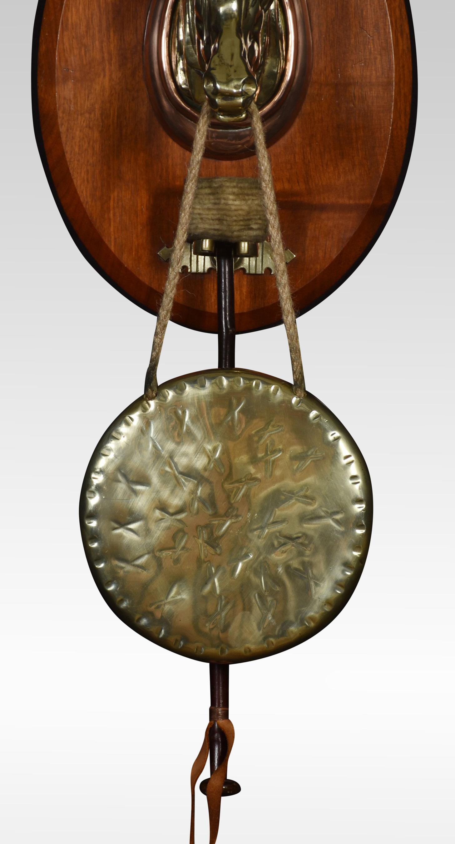 Wall hanging dinner gong, the mahogany backplate mounted with brass horse head supporting the circular gong. Together with a hammer.
Dimensions
Measures: Height 27 Inches
Width 10.5 Inches
Depth 7.5 Inches.