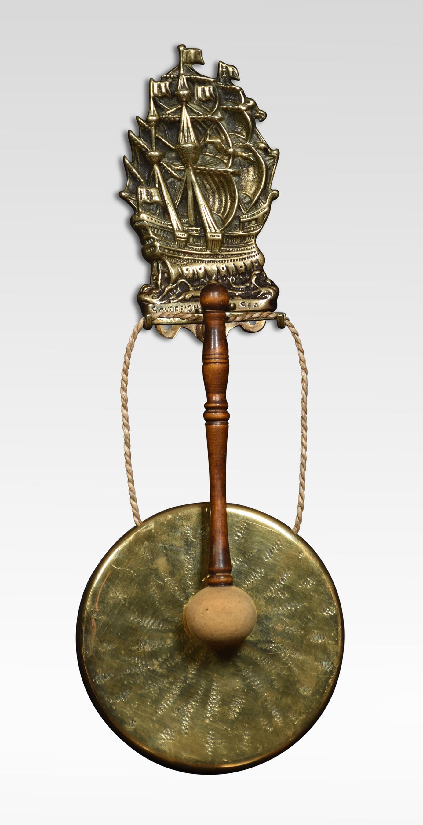 Wall hanging dinner gong, the brass backplate depicting the Sovereign of the Seas, a clipper ship built in 1852. Above scrolling hooks supporting the circular gong. Together with original hammer.

Dimensions
Height 18 Inches
Width 6