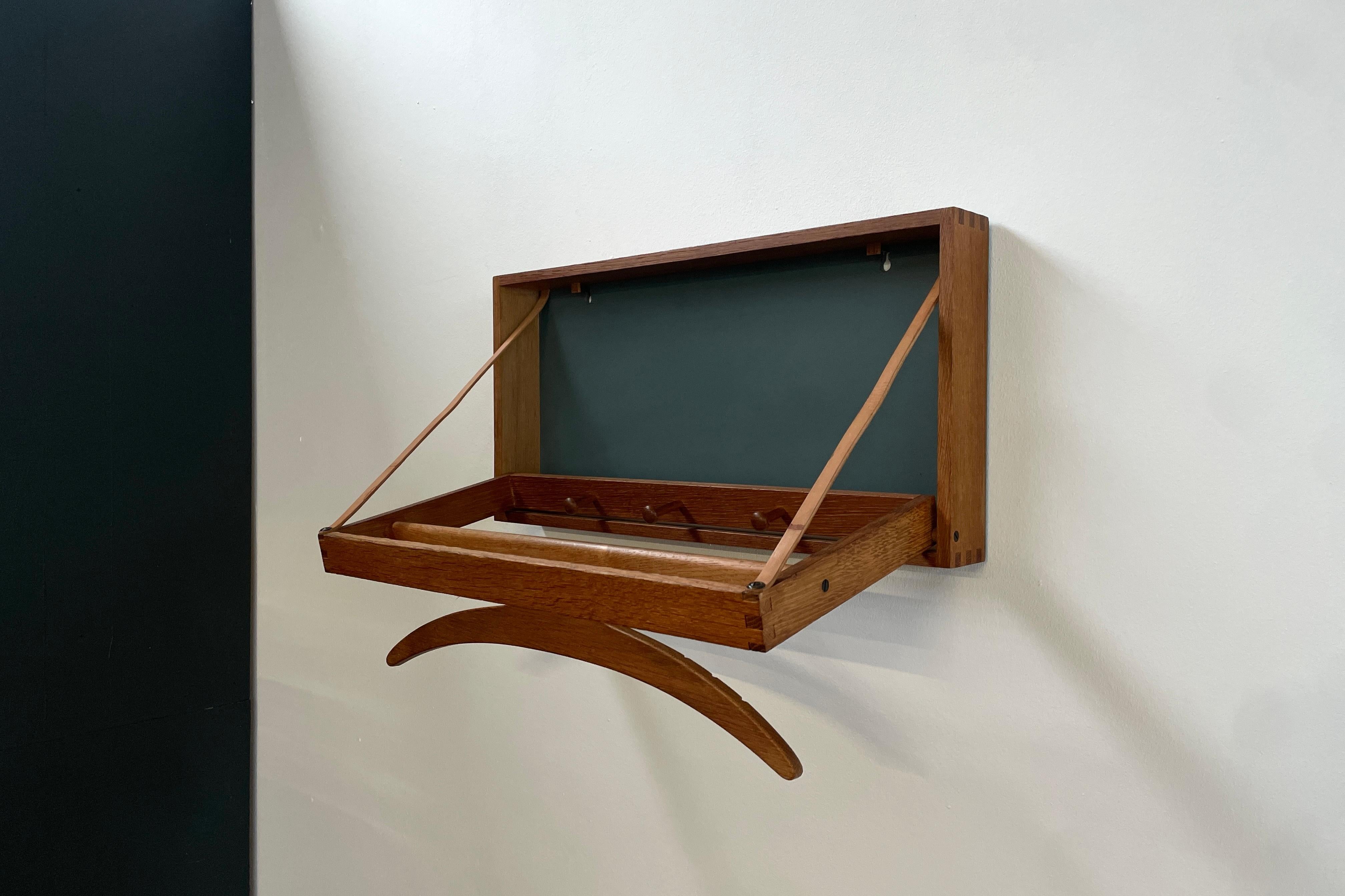 Wall hanging valet / coat rack by Adam Hoff And Poul Østergaard for danish furniture maker VIRUM Møbelsnedkeri.
Made in the early 1960´s.
Very good condition. Rare production in solid oak wood, leather and blue-grey formica.
