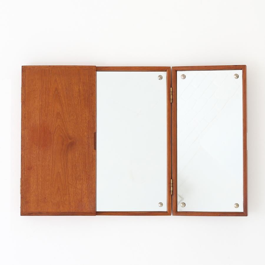 Three-winged, wall-hung teak mirror with two doors and brass hinges. Maker Ludvig Pontoppidan.