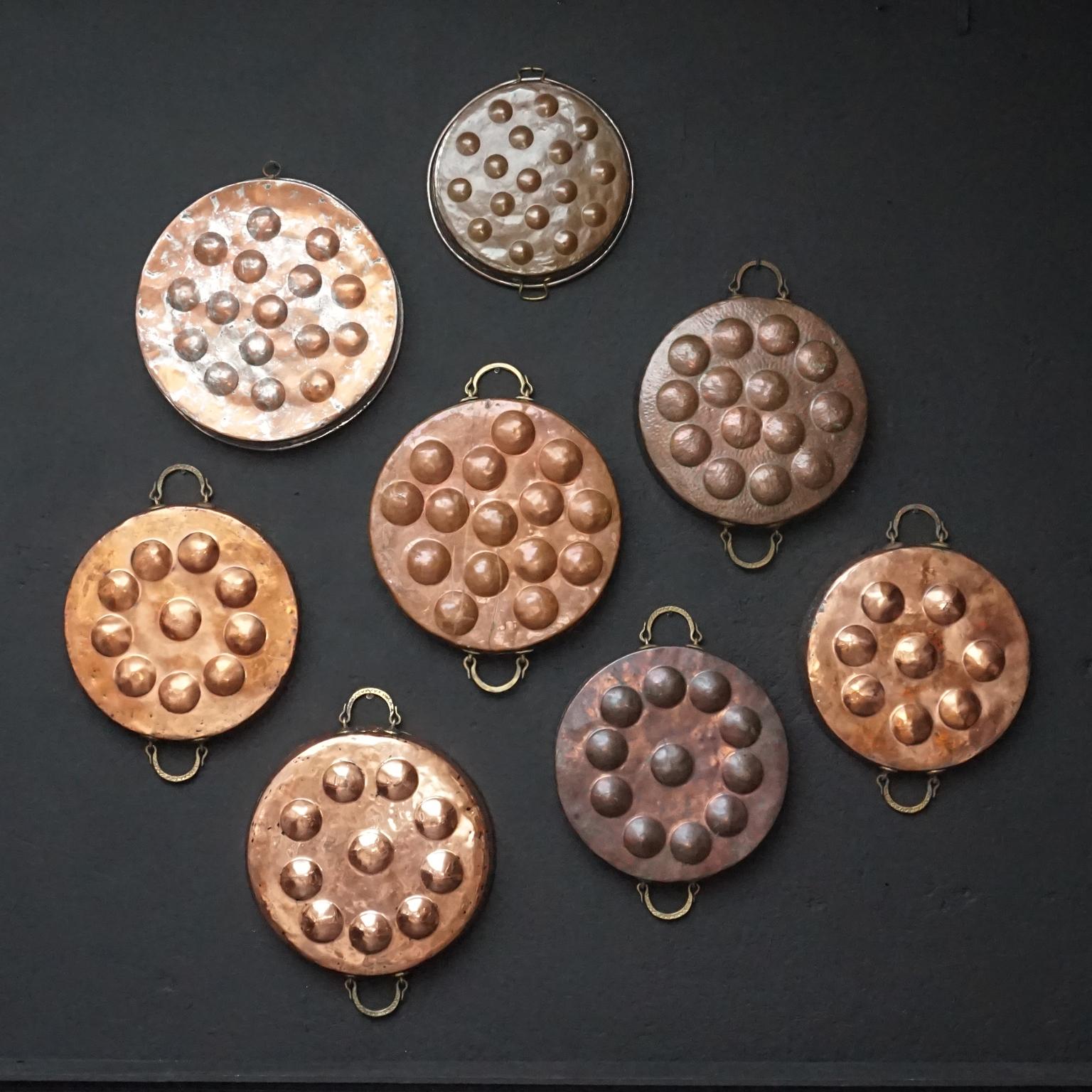 Lovely set of eight large 19th century antique French copper egg poacher copper pans.
Hand-hammered, tin lined with hand cast brass handles.

I'm told they where used for egg-poaching or maybe for cooking snails (escagots). 
Either way this is a