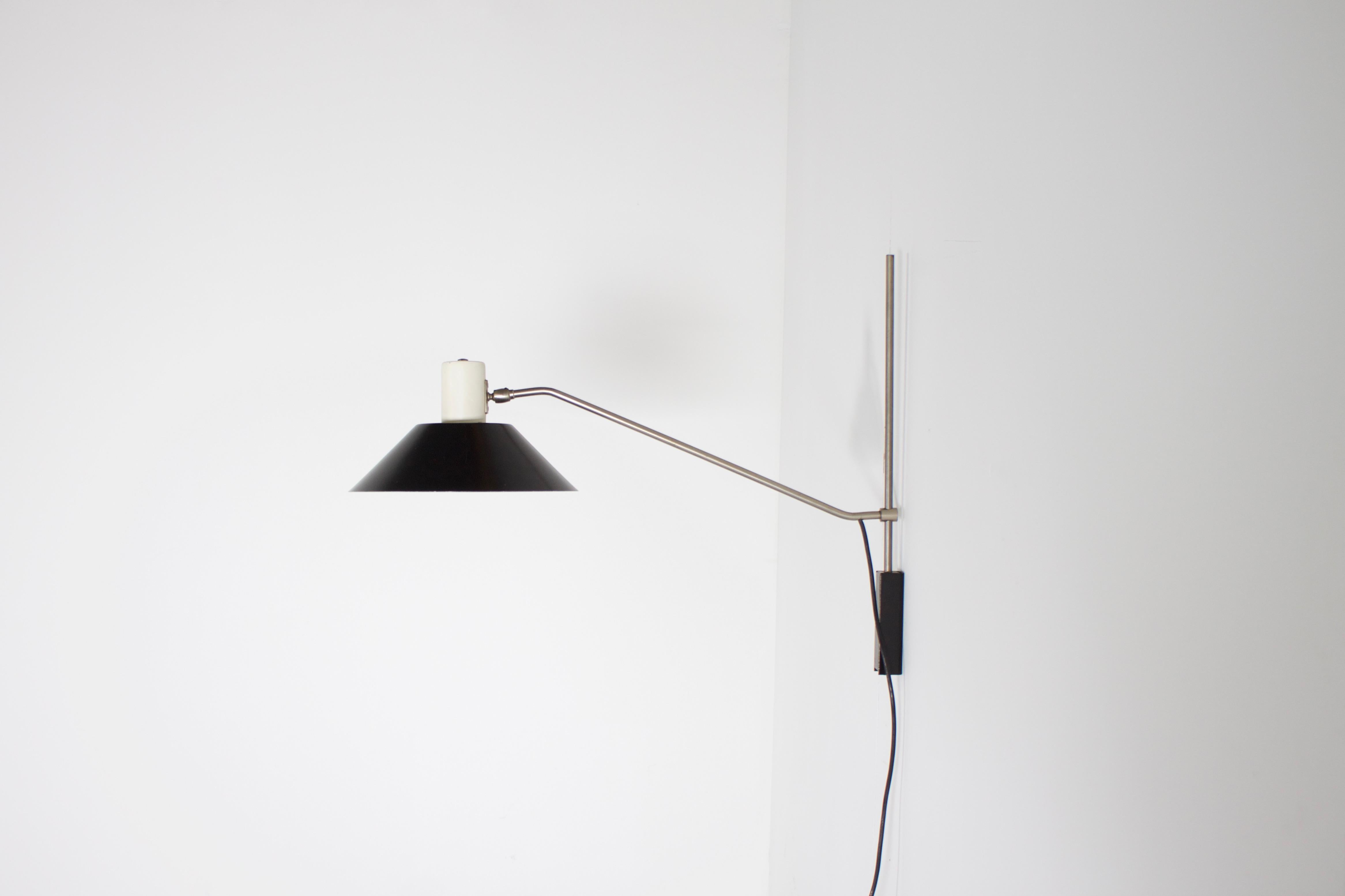 Modernist wall lamp, model 7078 in very good original condition.

Designed by Jan Hoogervorst, Netherlands, 1958.

Manufactured by Anvia Almelo.

The lamp has a black and white metal shade which can pivot and can be rotated 180 degrees.

The shade