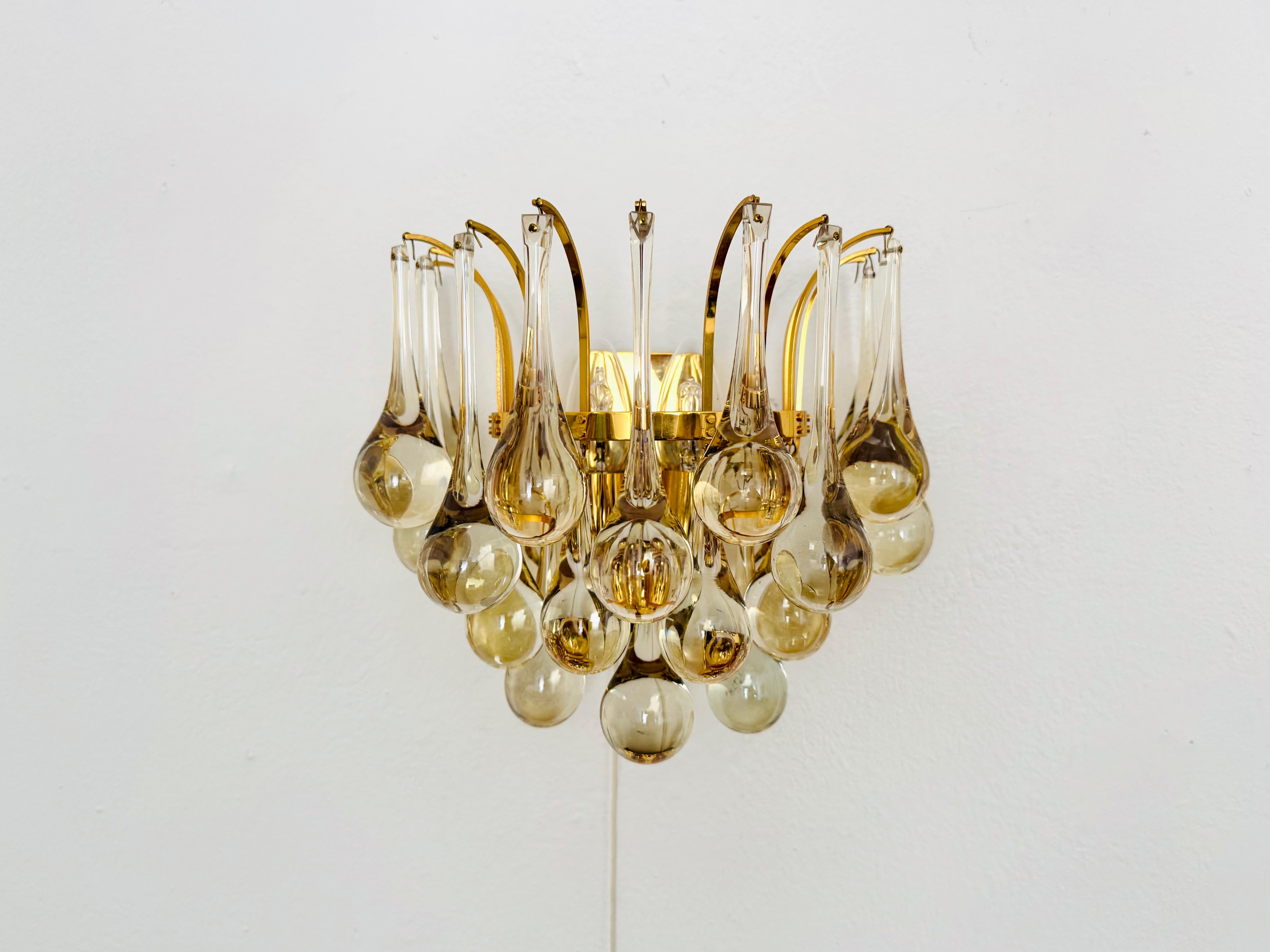 Impresionante aplique de cristal de los años 60.
Un diseño excepcionalmente logrado y una artesanía de muy alta calidad.
Las 20 gotas de cristal crean un espectacular juego de luces en la habitación.
Muy lujoso y un valor añadido para cualquier