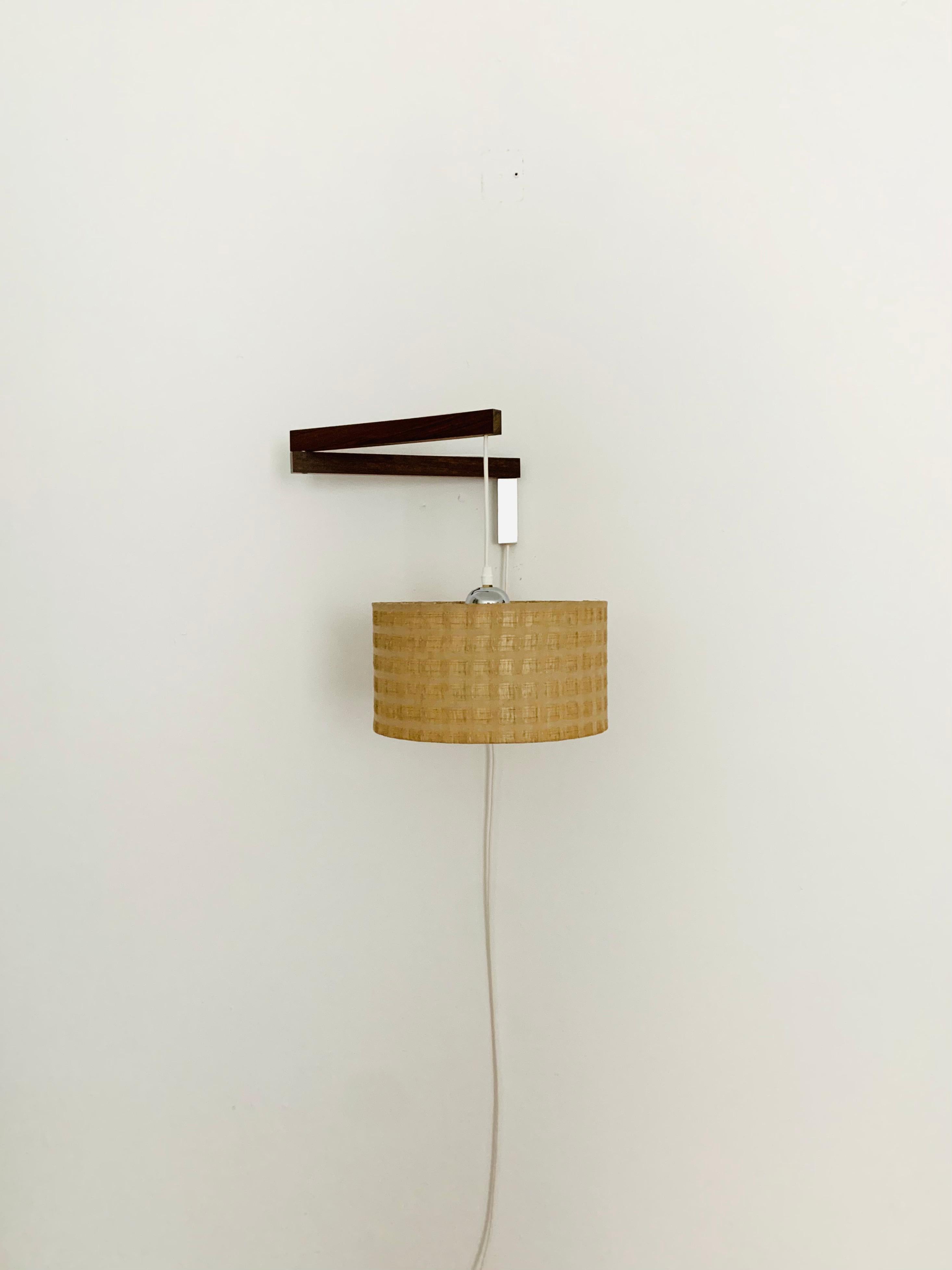 Wonderful wall lamp from the 1960s.
Great and exceptionally minimalistic design with a fantastically elegant look.
Very nice swiveling rosewood arm.
The lampshade creates a spectacular play of light and creates a very cozy