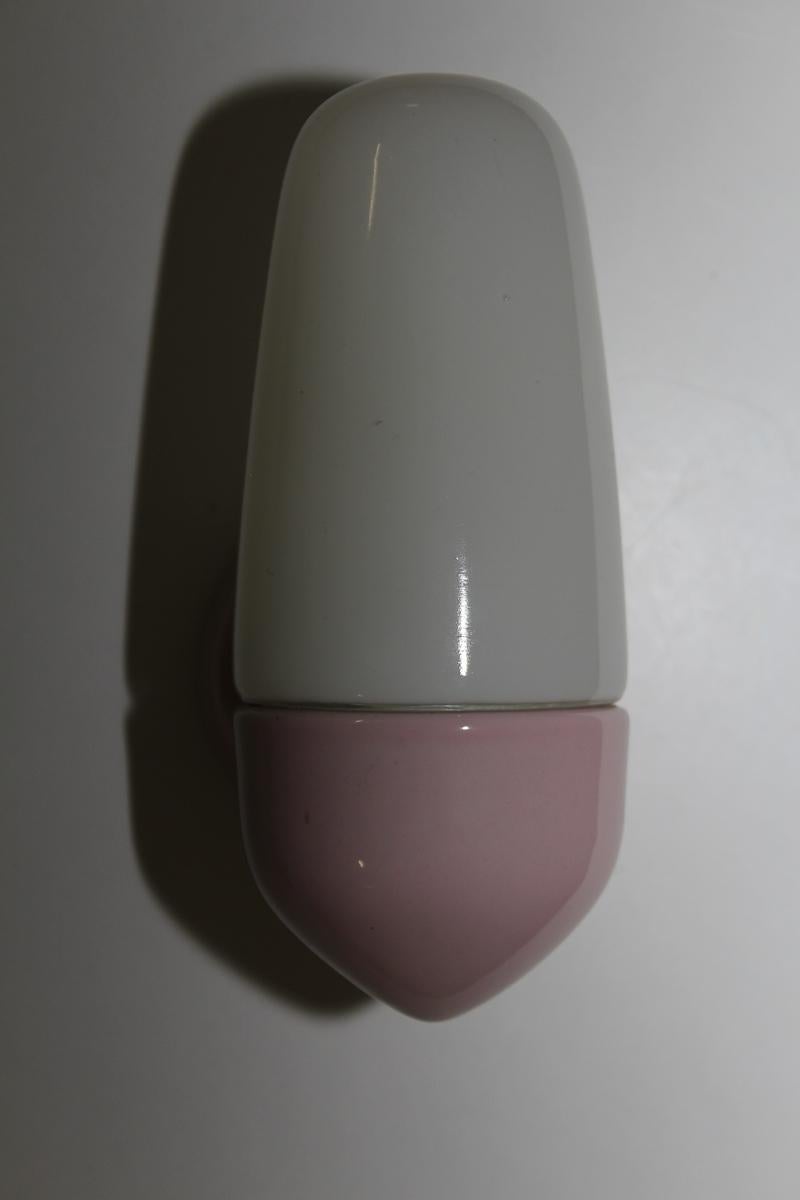 Classic mirror light by Wilhelm Wagenfeld, made of porcelain with a pink glaze. Original from the 1950s.