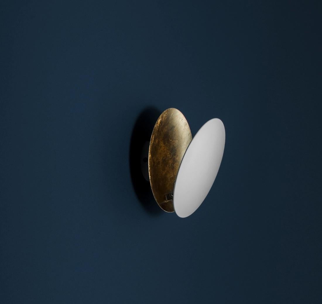 Lederam W incarne la précision d'un geste dessiné dans l'espace. Le disque de feuilles noir/doré aux couleurs chaudes et douces entoure un module LED ultraplat, créant ainsi une lampe murale fine et élégante aux lignes sinueuses et incurvées. Sa