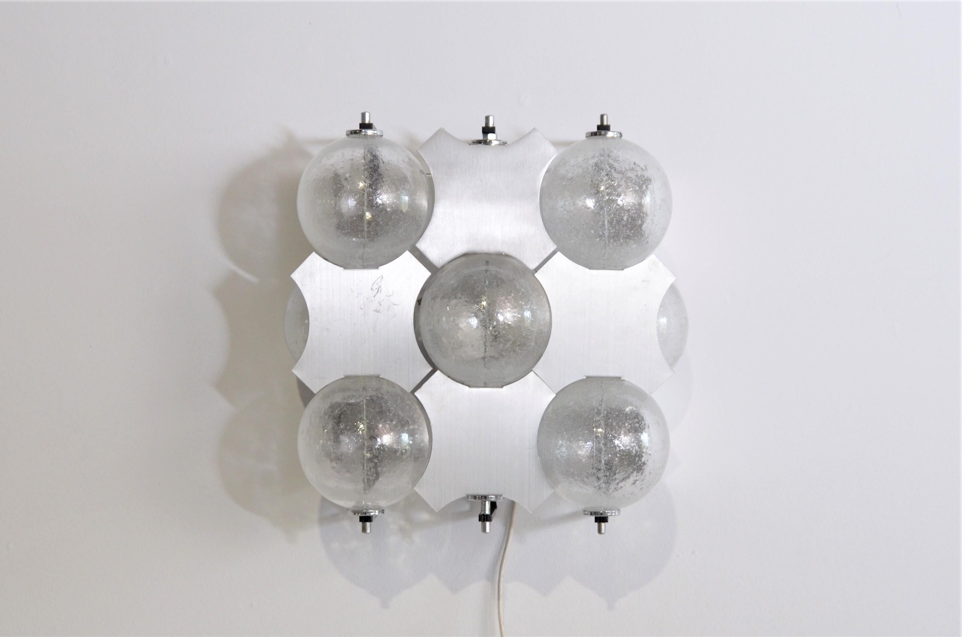Wall lamp model C1645 by RAAK, Amsterdam with five large glass spheres. The aluminum partitions between the balls are movable so the reflection of the light can be controlled somewhat. 
The lamp has two lamp holders for 60 watt E27 bulbs.