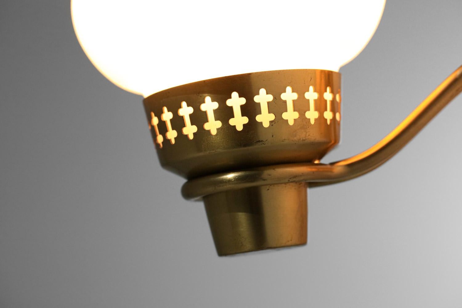 Lampada da parete scandinava del designer svedese Hans Bergström edita da ASEA negli anni Sessanta. Struttura in ottone massiccio con fori. Diffusore in opalina bianca opaca a forma di goccia. Condizioni vintage molto buone, impianto elettrico