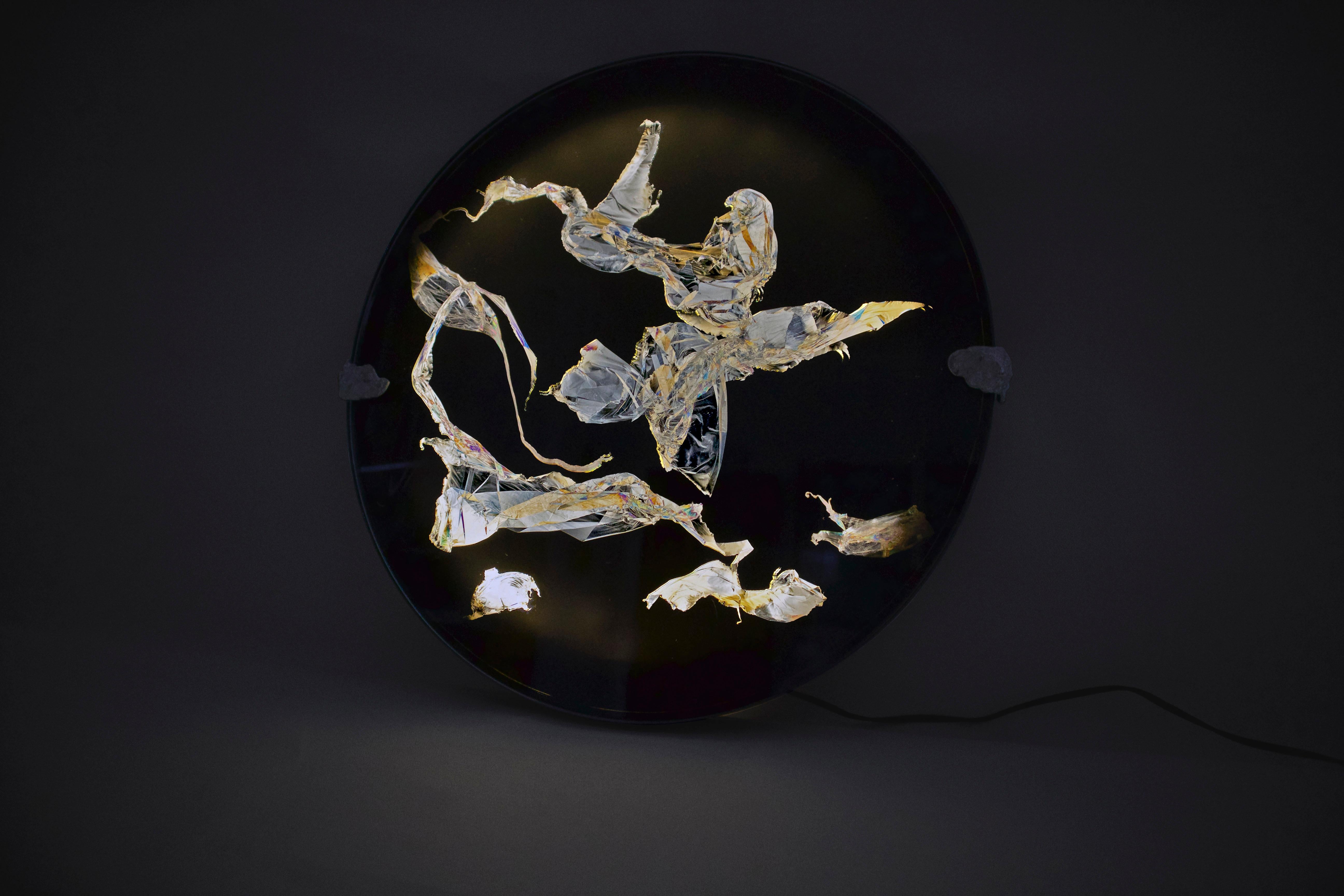 Wall lamp I by Kajsa Willner
Dimensions: 36,5 x 4 cm
Materials: polarized filters, disposable plastic

POLARIZED PORTRAITS
Polarized portraits is a set of wall lights and lamps that use polarized light to reveal stress patterns in clear