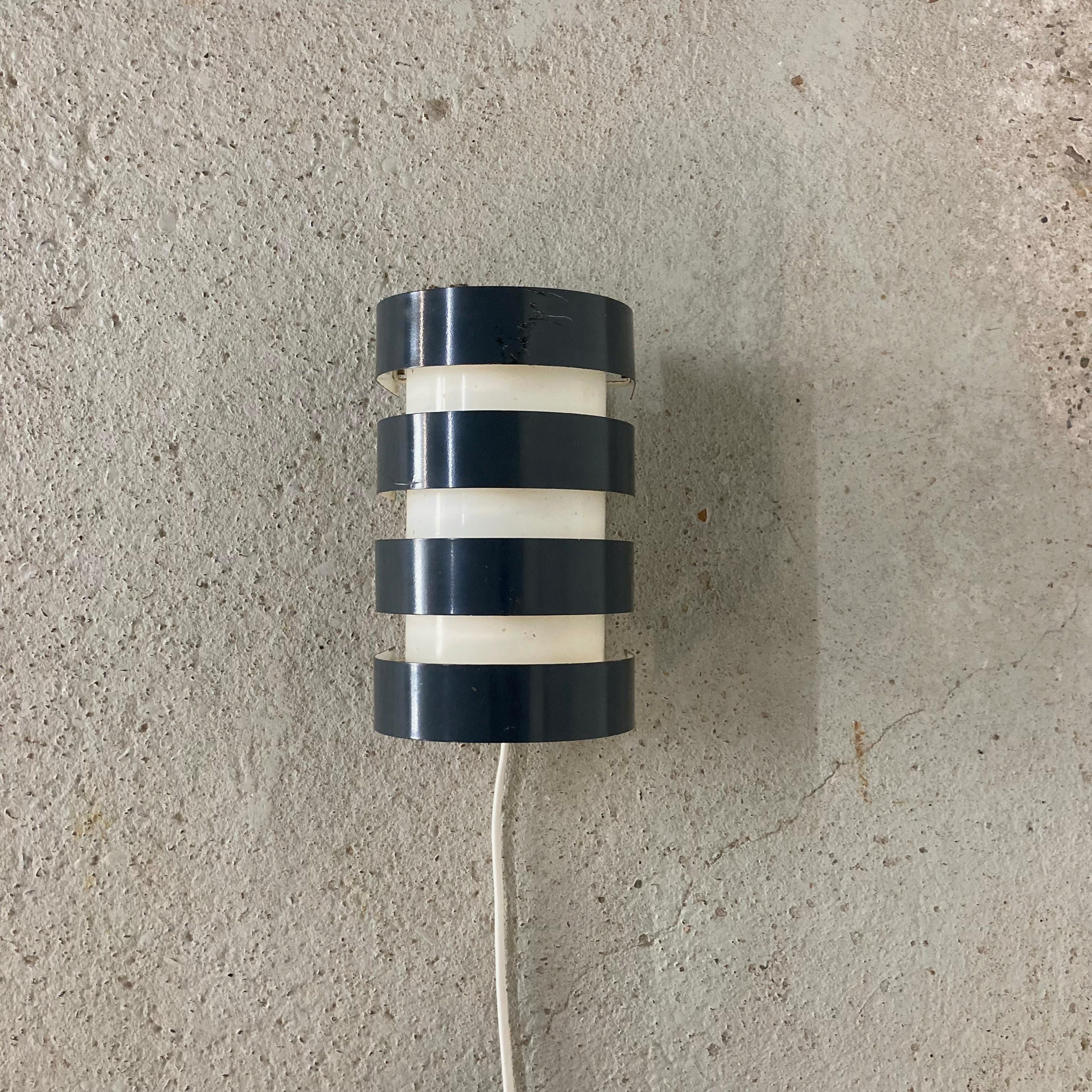 Mid century modern wall light by Itsu.
Made in Finland in the 1950s.
Model AH85.

White and dark blue/gray lacquered metal.

Marked accordingly.

Nice ambient light.

1 x E27 socket. EU plug and switch.
