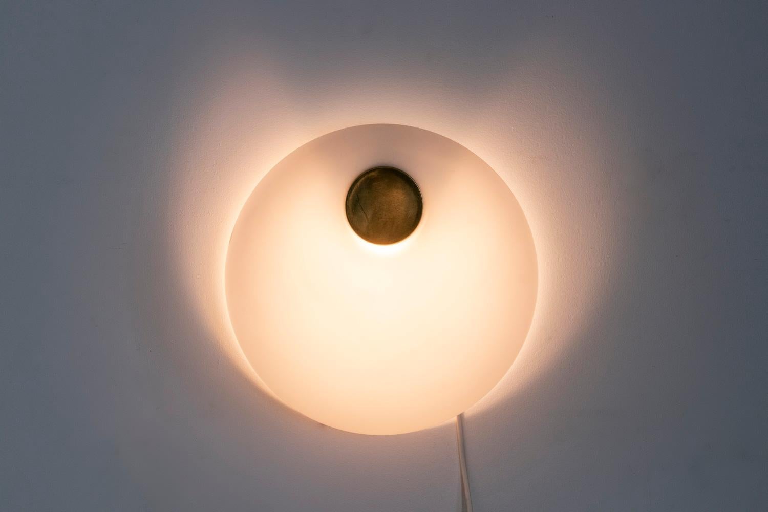 Wall lamp in Murano glass, in white opaline. Brass circular shape in the center.

Italian work made in the 1970s.