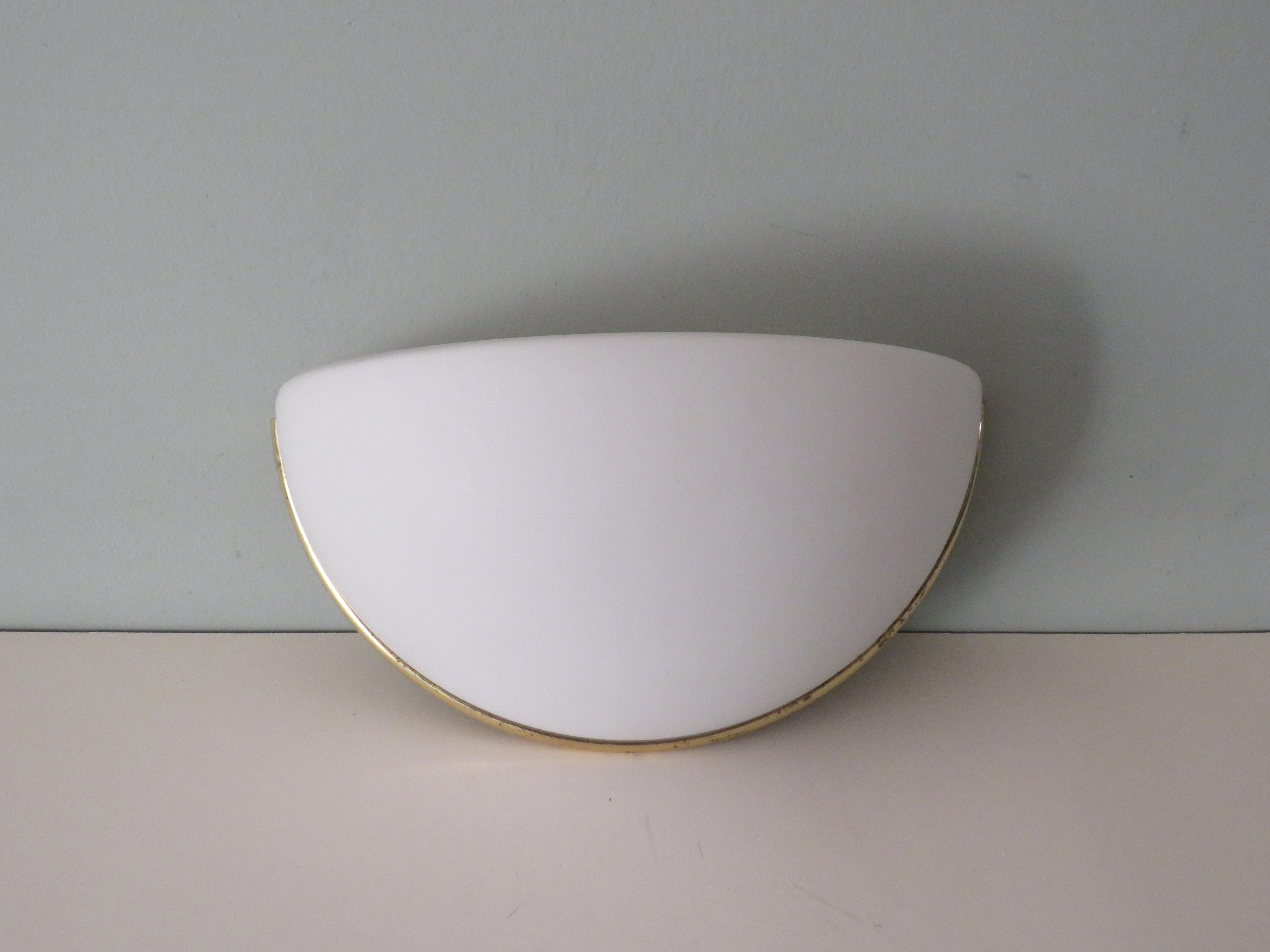 Semi-sphere-shaped wall lamp in opaline glass in a gold-coloured brass frame. The lamp is not open at the top but closed.
The lamp is equipped with 1 E 14 fitting and complete with wall mounting plate.
The lamp is in good condition, the brass edge