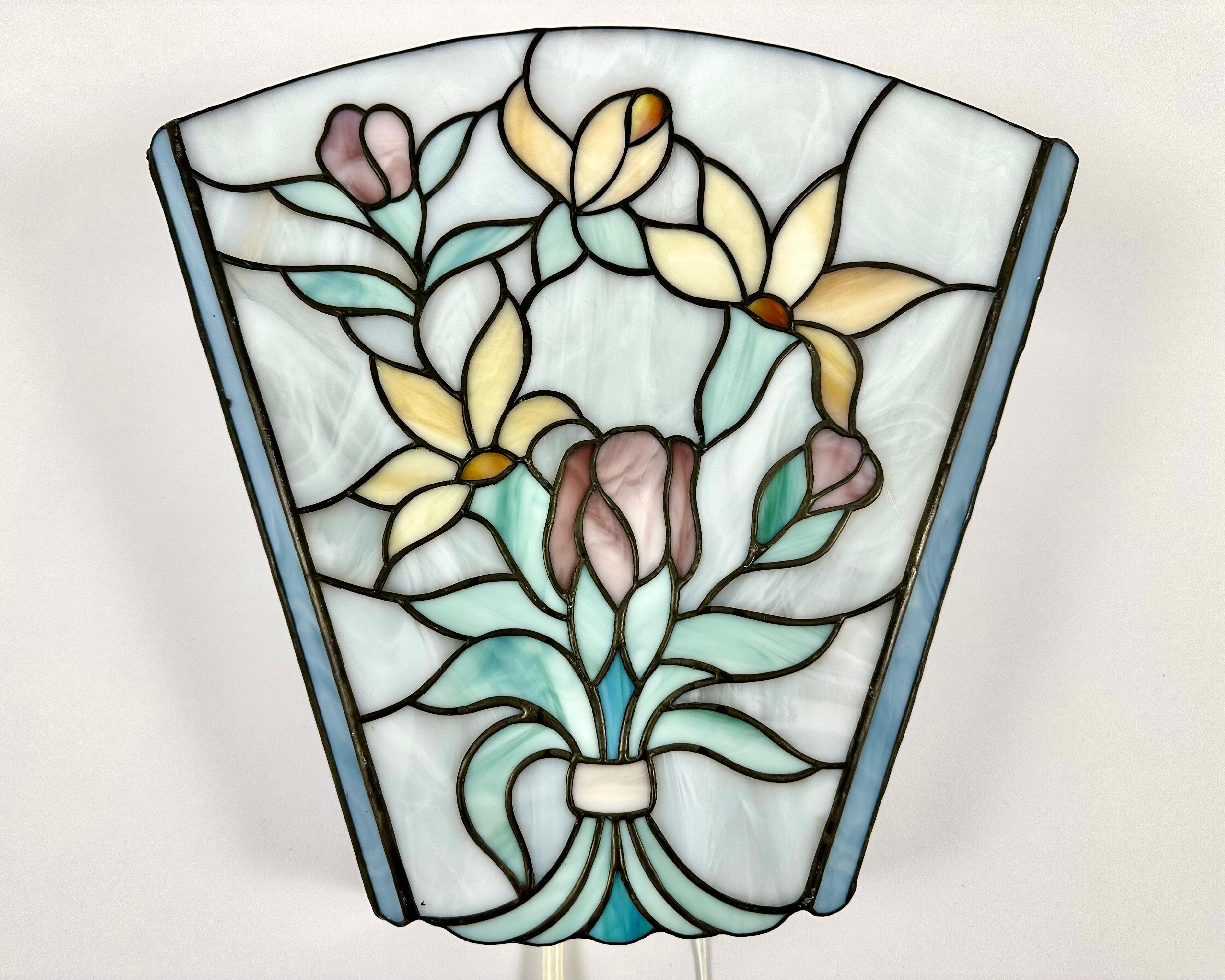 L'applique murale Botanical Tiffany.

Allemagne, années 1960.

Le verre d'art magnifiquement taillé à la main est soigneusement assemblé pour rendre la lampe unique et magnifique.

Lampe en verre teinté. L'abat-jour est réalisé selon la technique