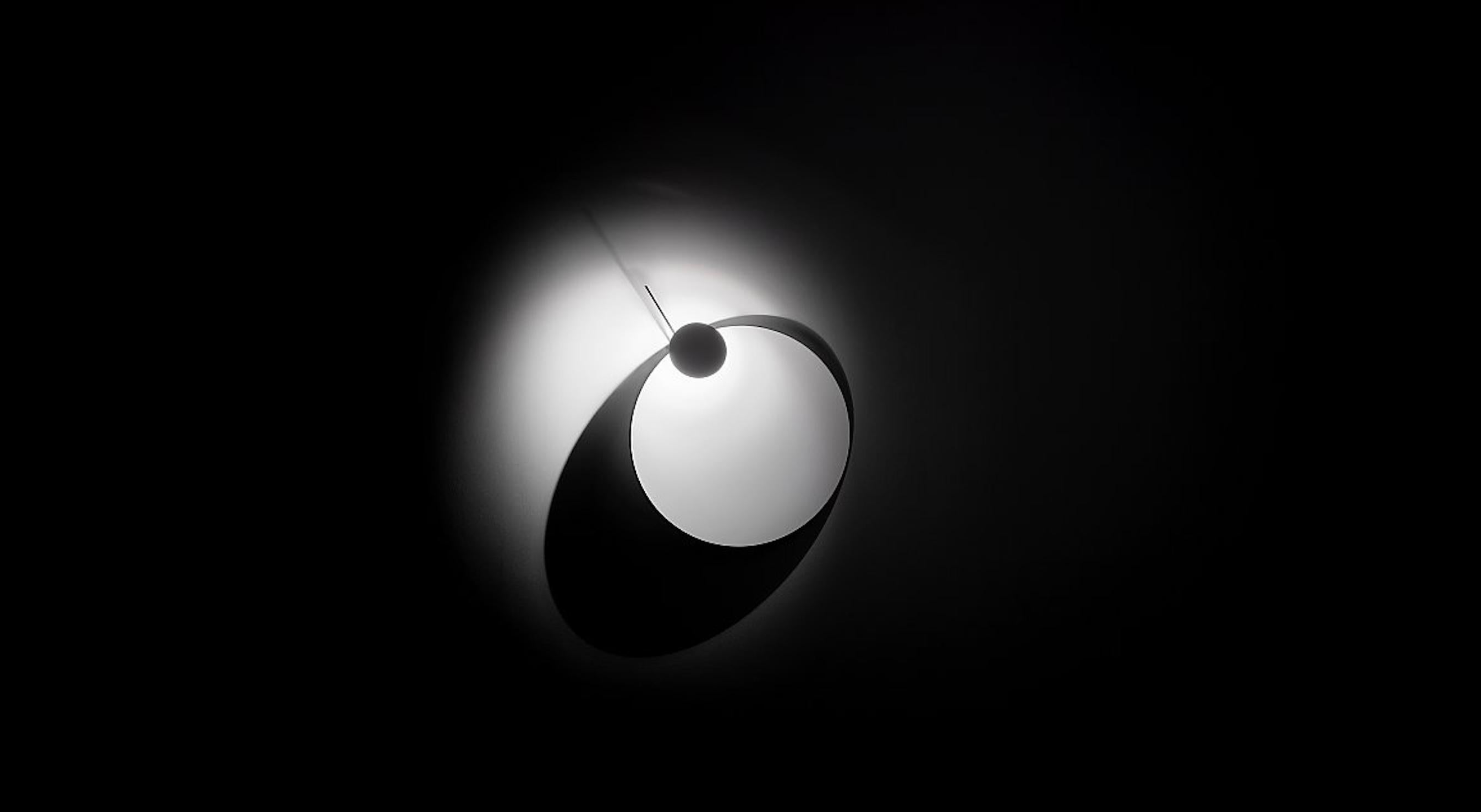 Model: Eclipse Ellipse
Designer: Ingo Maurer (2017)

Eclipse Ellipse is designed as a wall lamp that not only illuminates but also creates shadow. When switched on, it generates graphic compositions of circles and ellipses. Both the inclination of